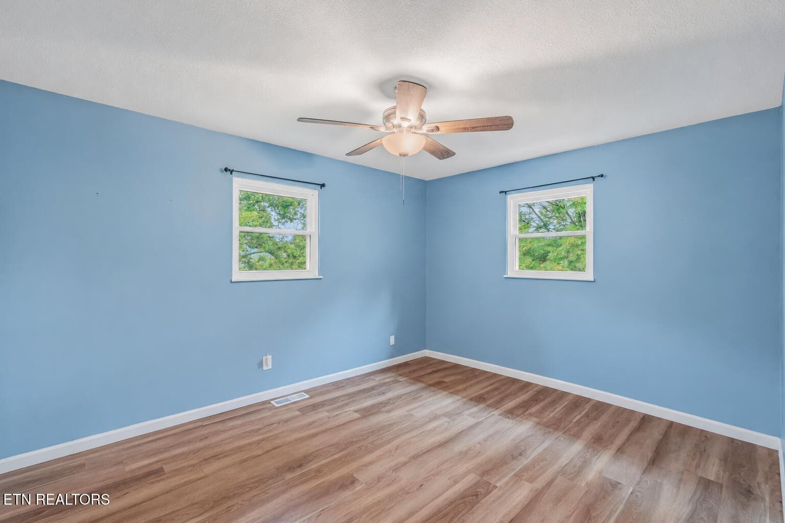Empty Blue Bedroom with Warm Wood Floors - 1221 Laurel Rd, Clinton, TN 37716