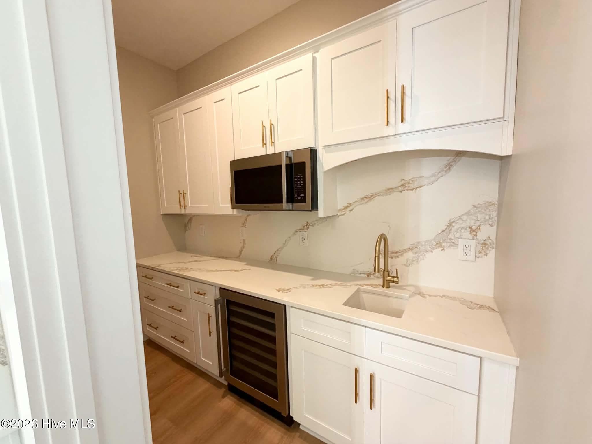Butler's pantry with microwave, wine fridge, custom counters, backsplash and cabinet pulls. - 550 Glenburnie Street NW, Calabash, NC 28467