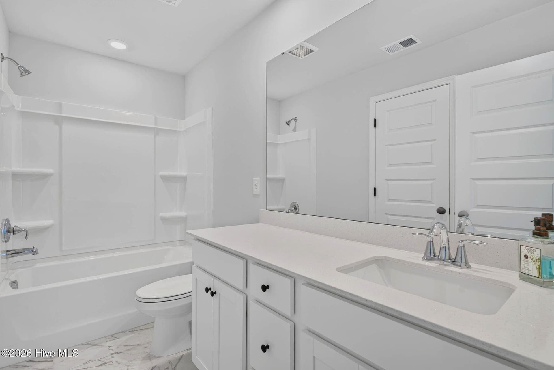 Upstairs full bathroom with dual-sink vanity, white cabinetry, and a tub/shower combination. - 3447 Sandhill Crane Drive SW, Ocean Isle Beach, NC 28469