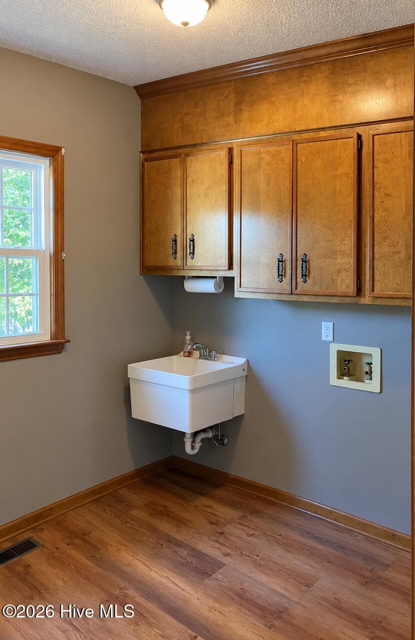 Laundry rm located off kitchen w/new flooring, sliding farmhouse style door, cabinets, sink and shelving for pantry space. - 4164 Quail Springs Circle, Augusta, GA 30907