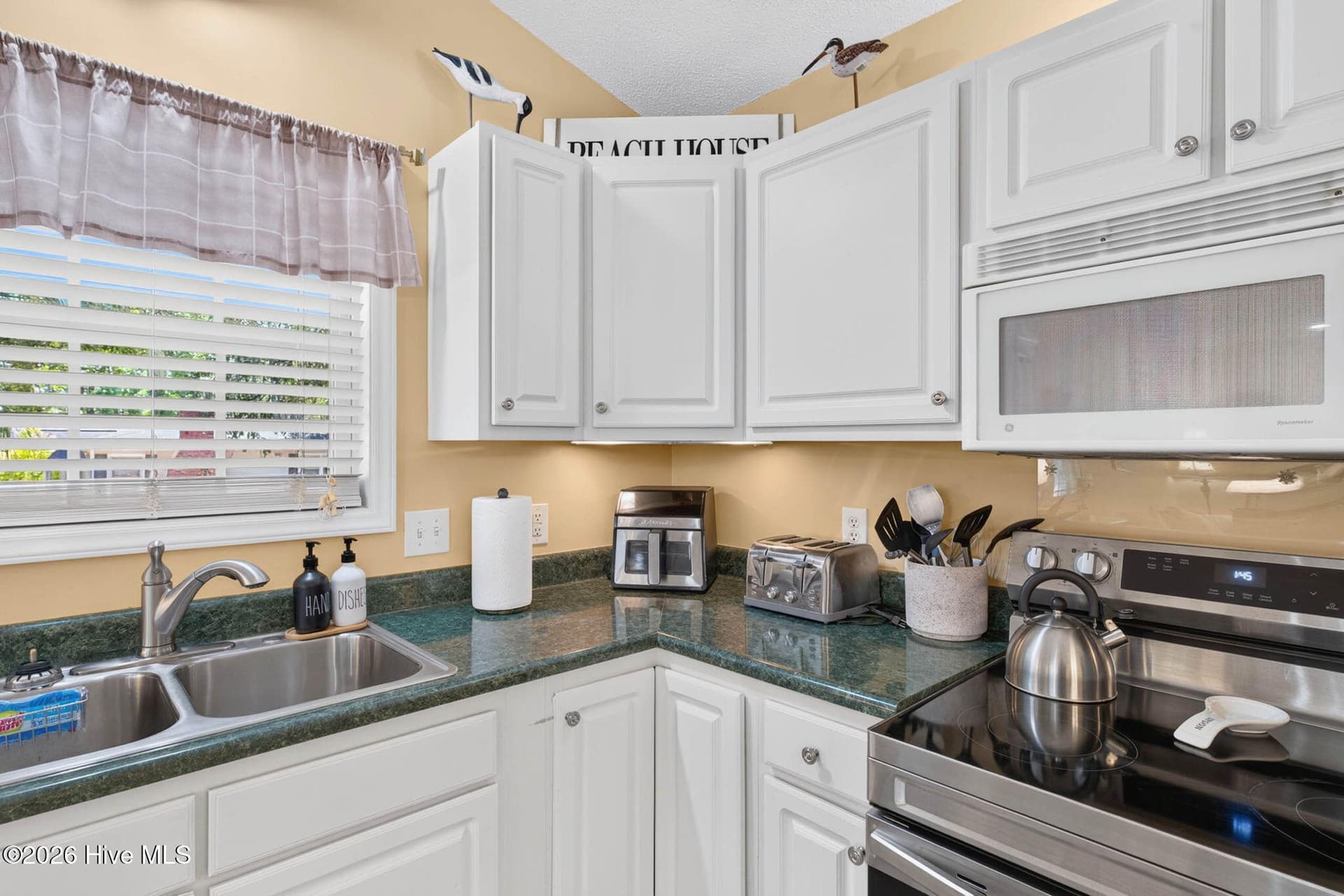 Natural light, white cabinetry, and generous workspace make this kitchen ready for everyday coastal living. - 1650 Frink Street SW, Ocean Isle Beach, NC 28469