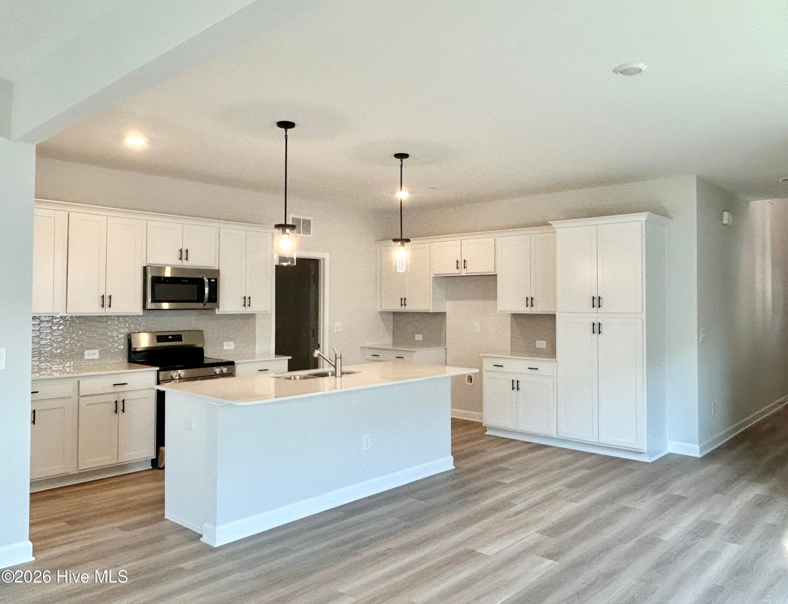 Stunning Kitchen includes Quartz Countertops, Stainless Appliances, Tile Backsplash, Beautiful Lighting fixtures and an abundance of Cabinets. - 4153 Workman Loop 68, Leland, NC 28451