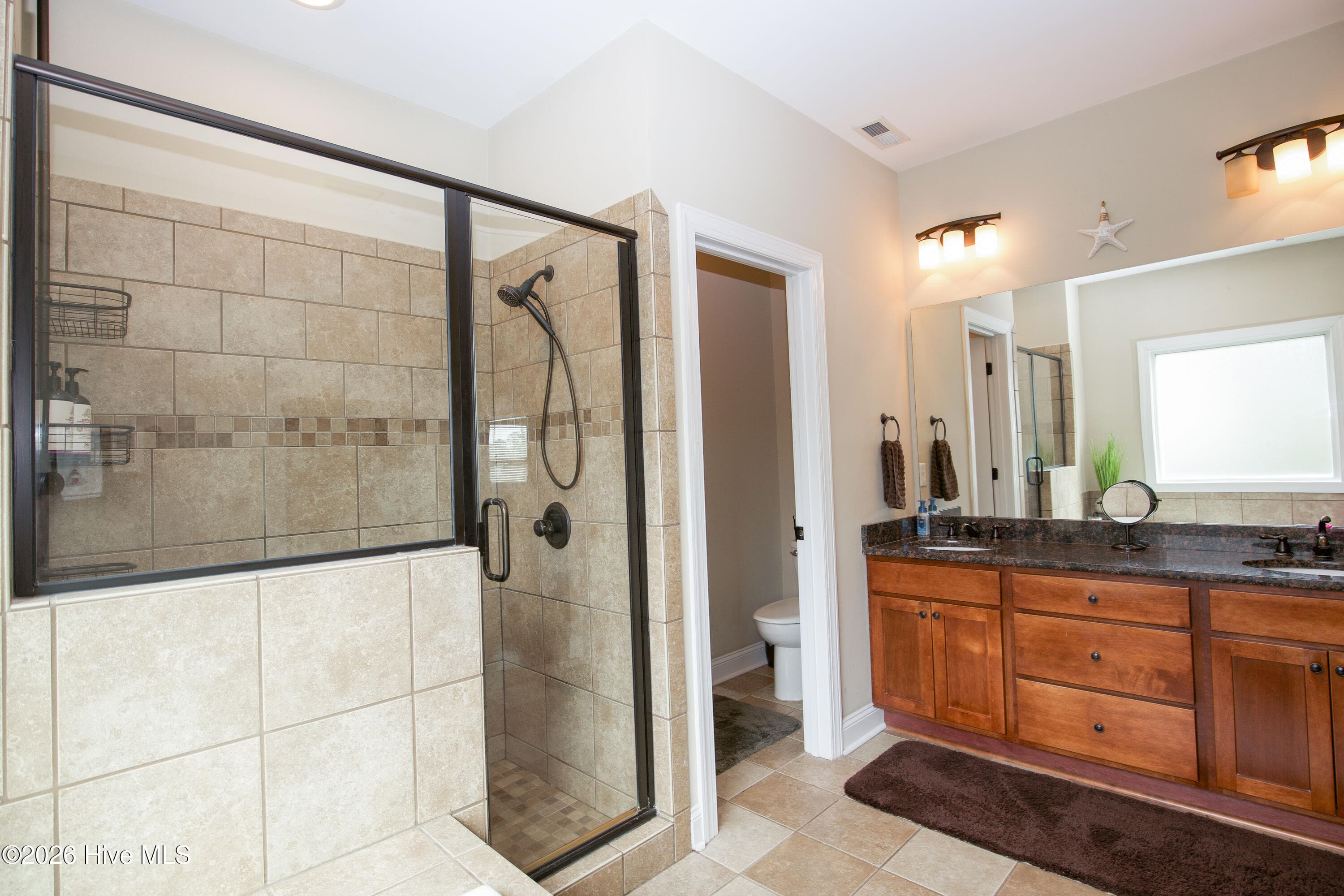 Primary bathroom with a tiled walk-in shower and vanity. - 899 Seagull Drive, Vass, NC 28394, Vass
