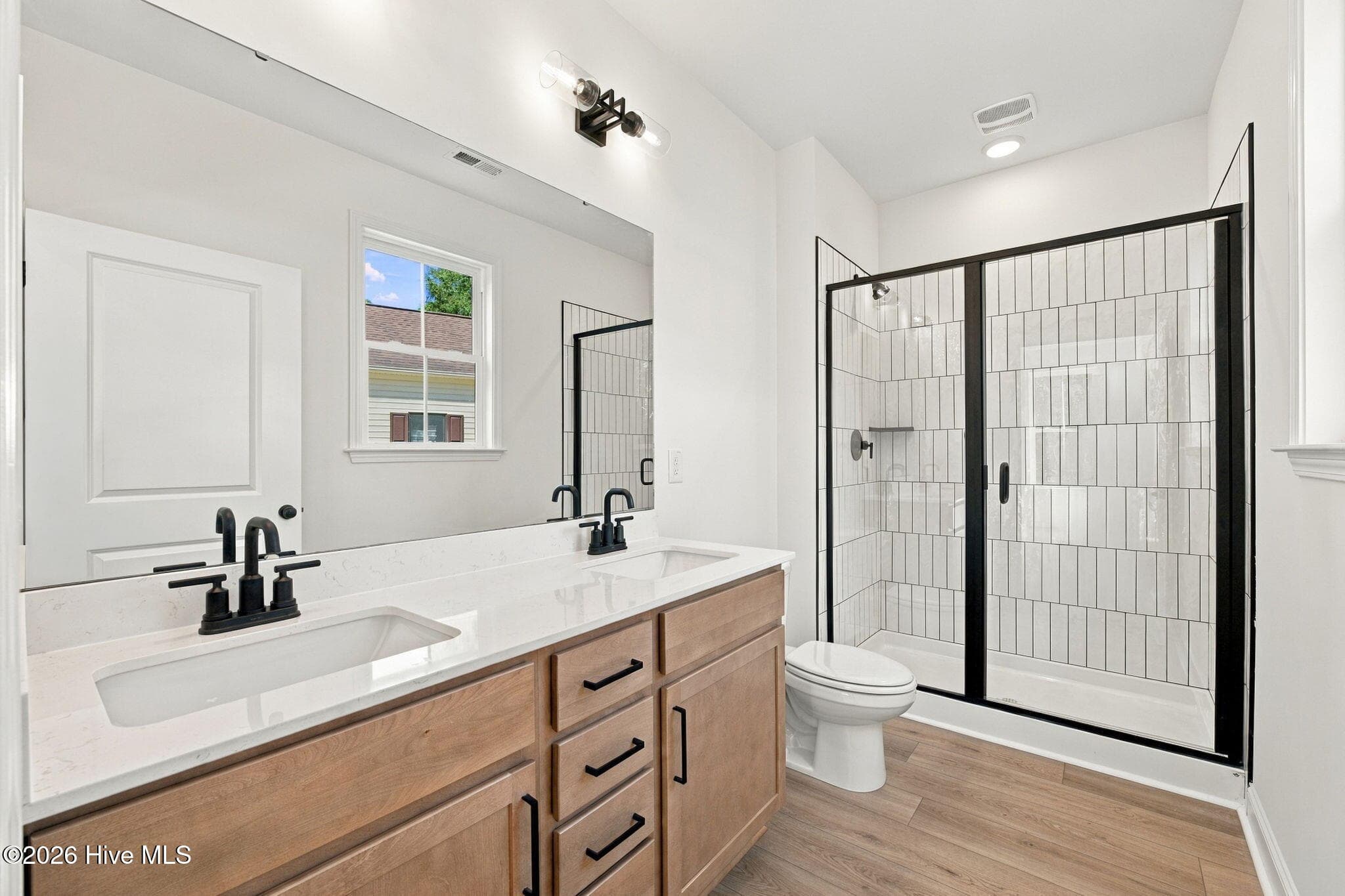Walk-In Bath features Quartz Counter, Dual Vanities and Walk In Glass Tiled Shower - 1224 Petite Terre Court, New Bern, NC 28560