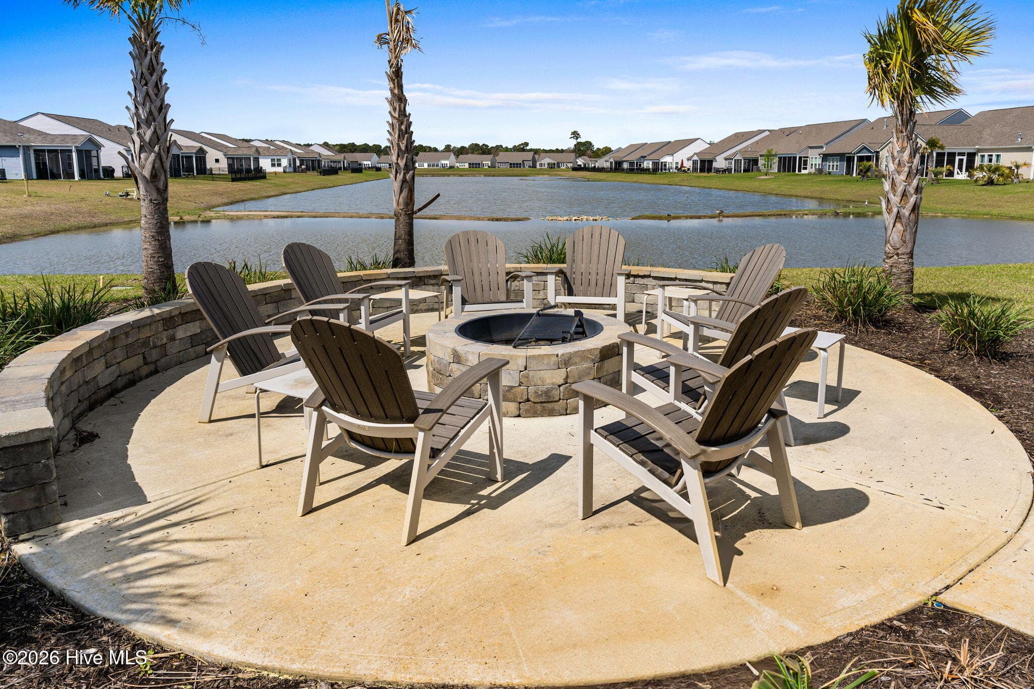 The community firepit and outdoor seating area overlook the pond, providing a peaceful place to gather with neighbors and friends. - 139 Eagle Claw Drive, Calabash, NC 28467