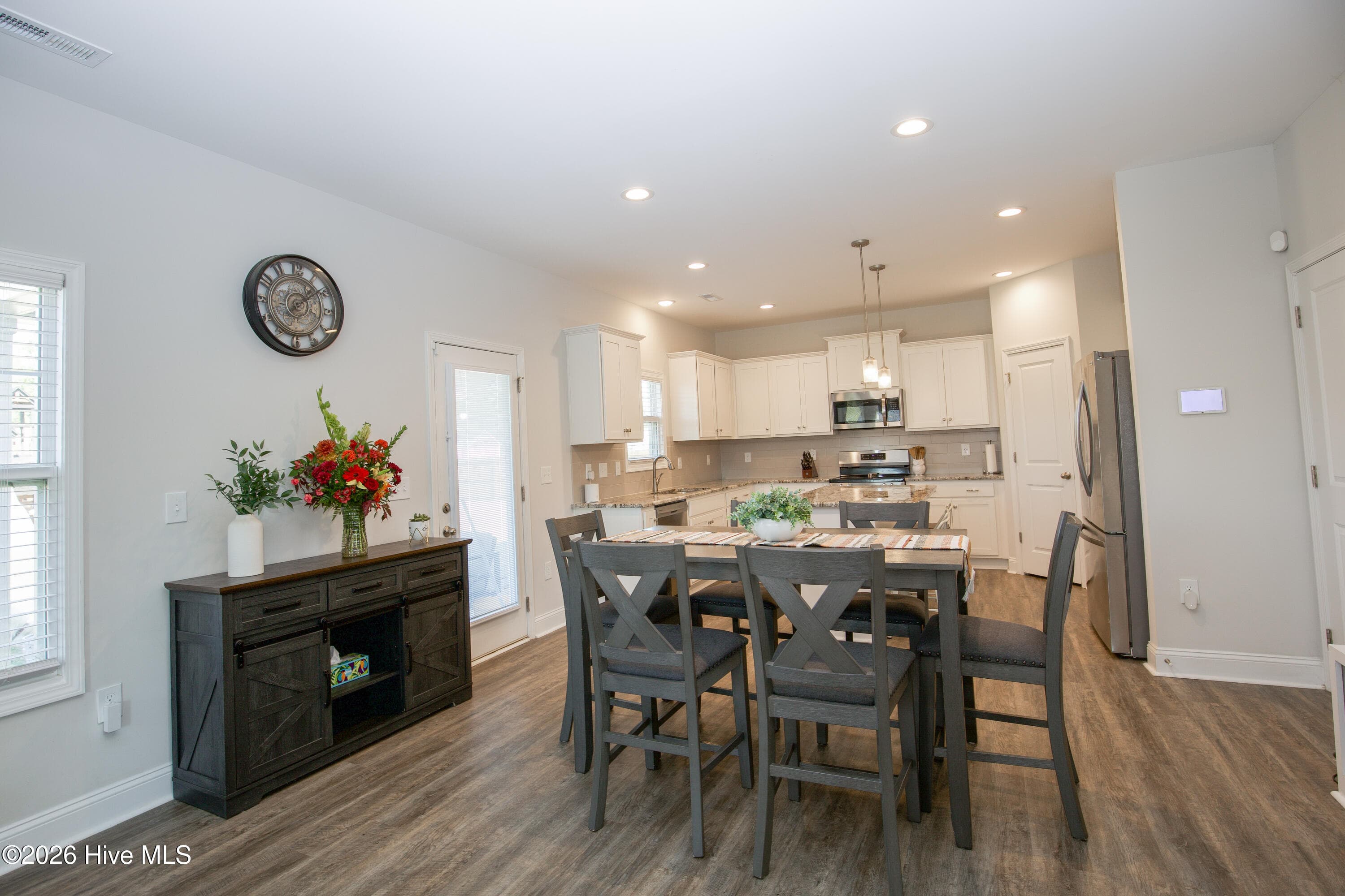 The dining area sits between the kitchen and the Great Room, with a window on one side and the rear door to the patio on the other. There is room for a full-size table and a sideboard along the wall. From the table you can see straight into the kitchen, so serving and clearing are simple. - 221 Vega Lane, Linden, NC 28356
