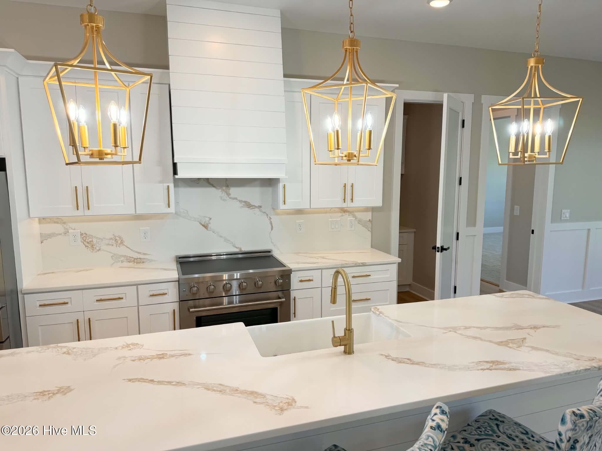 Kitchen area. Custom lighting, counter tops, backsplash, faucet and cabinet hardware. Upgraded induction range. - 550 Glenburnie Street NW, Calabash, NC 28467