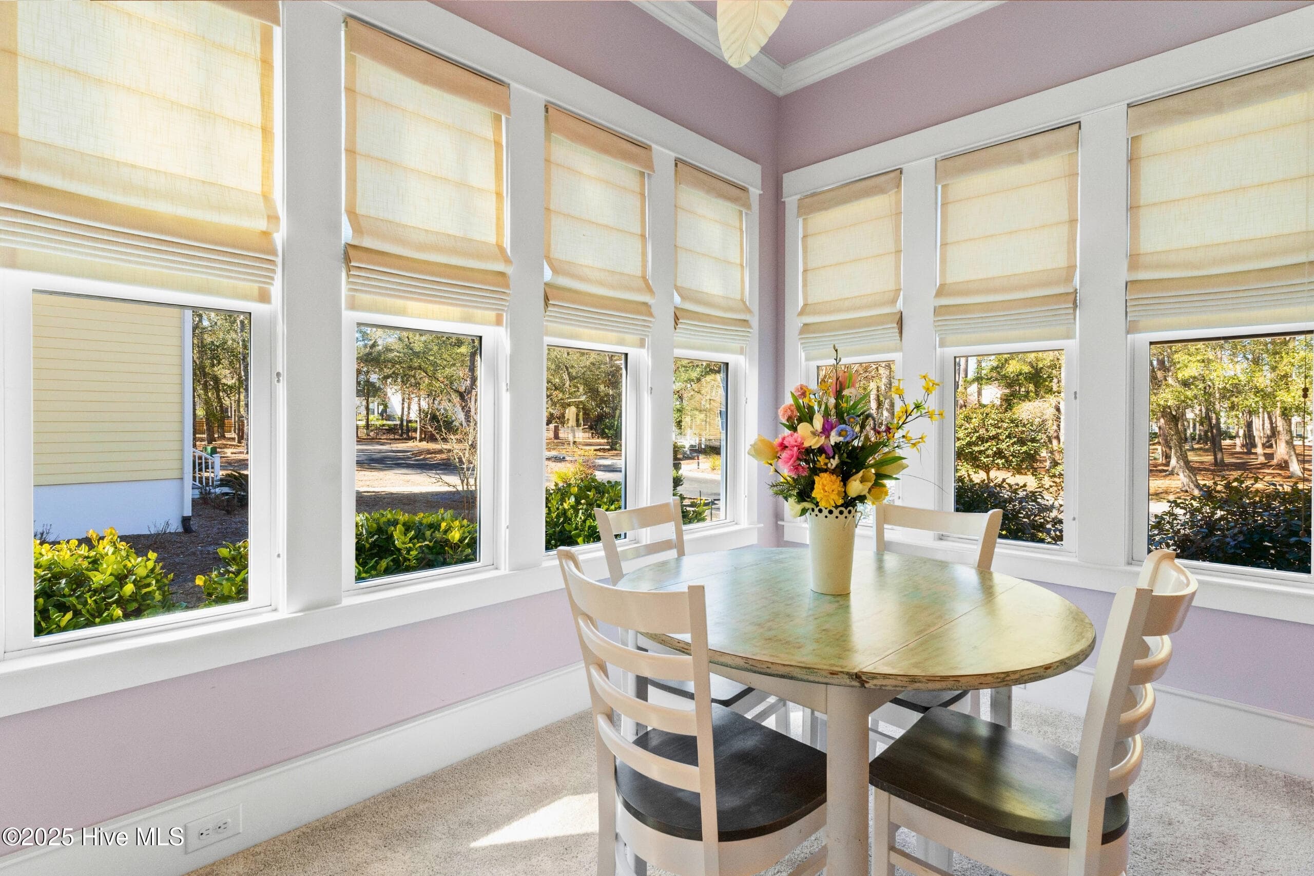Sun-drenched dining area surrounded by panoramic windows and custom wainscoting details. - 9100 Fountain Street SW, Calabash, NC 28467