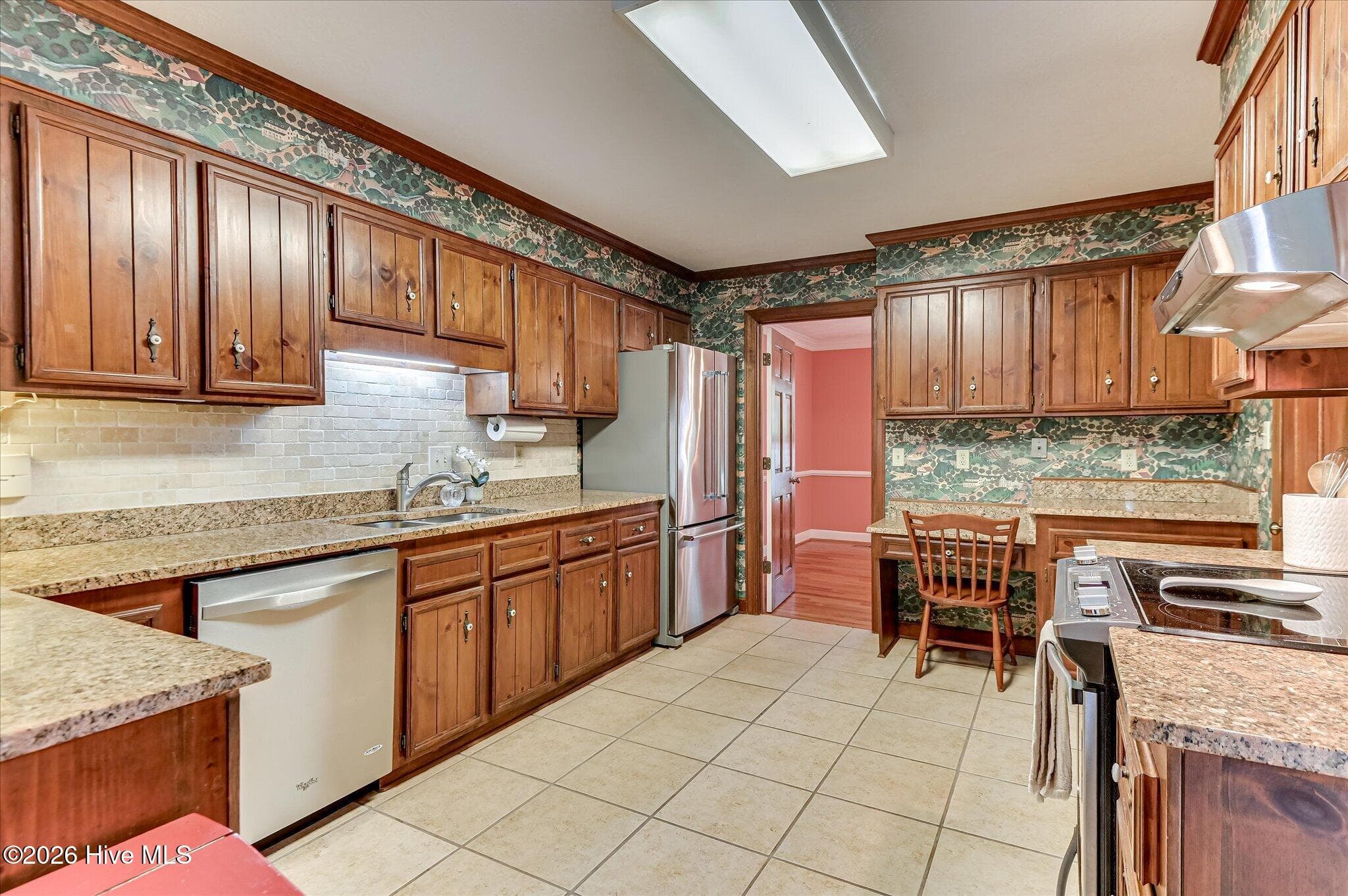 The Kitchen includes granite countertops, stainless steel appliances, a pantry, a built-in desk, and an adjoining breakfast area with French doors to the sunroom. - 307 Wakefield Lane N, Martinez, GA 30907