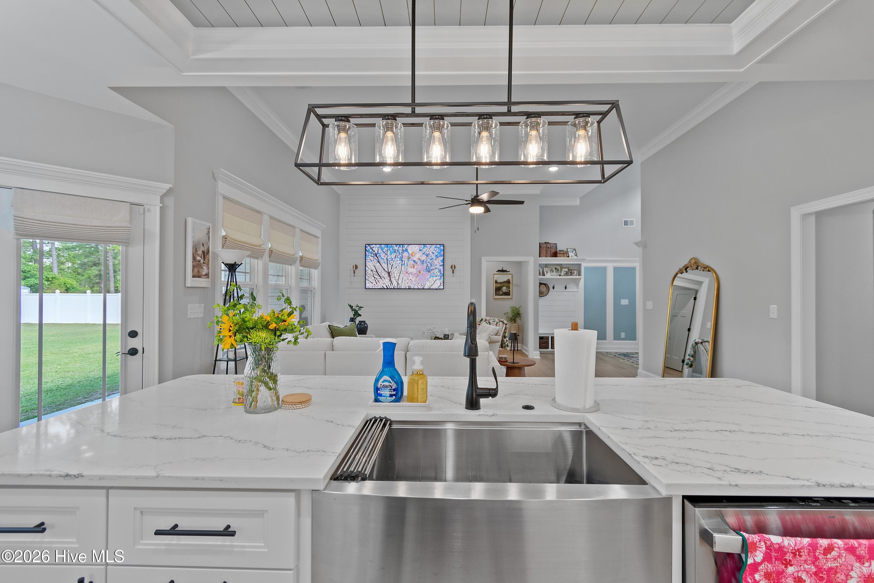 The kitchen is designed for everyday living and effortless entertaining, featuring a beautiful tray ceiling, task lighting, and a spacious center island perfect for cooking, gathering with family, and creating lasting memories. - 299 Boundaryline Drive NW, Calabash, NC 28467