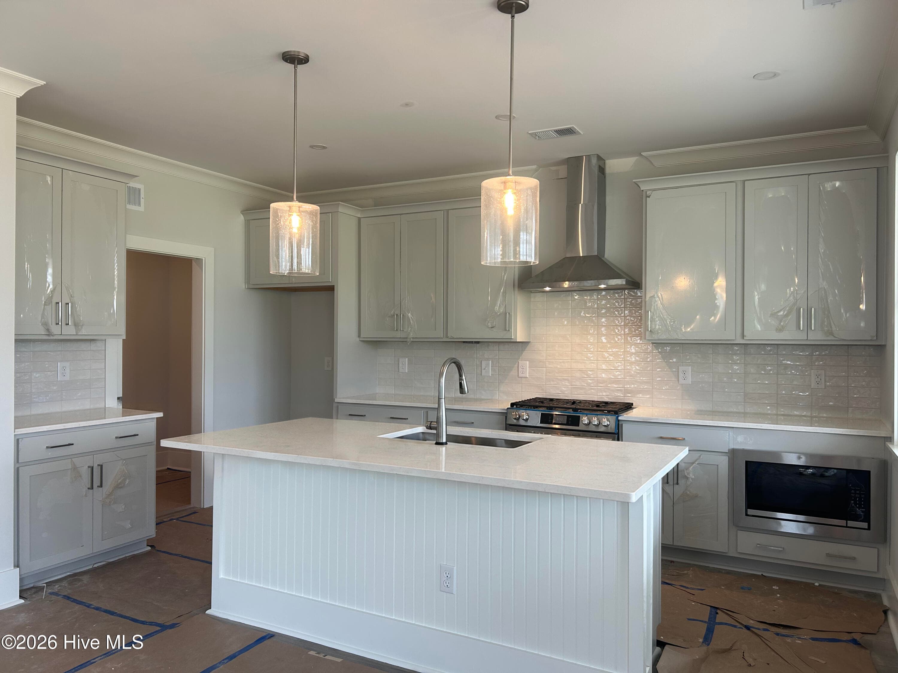 Kitchen with stainless steel gas range, vent hood, microwave and dishwasher. Quartz Countertops and 42" upper cabinets. - 5202 Moonshell Loop, Wilmington, NC 28412
