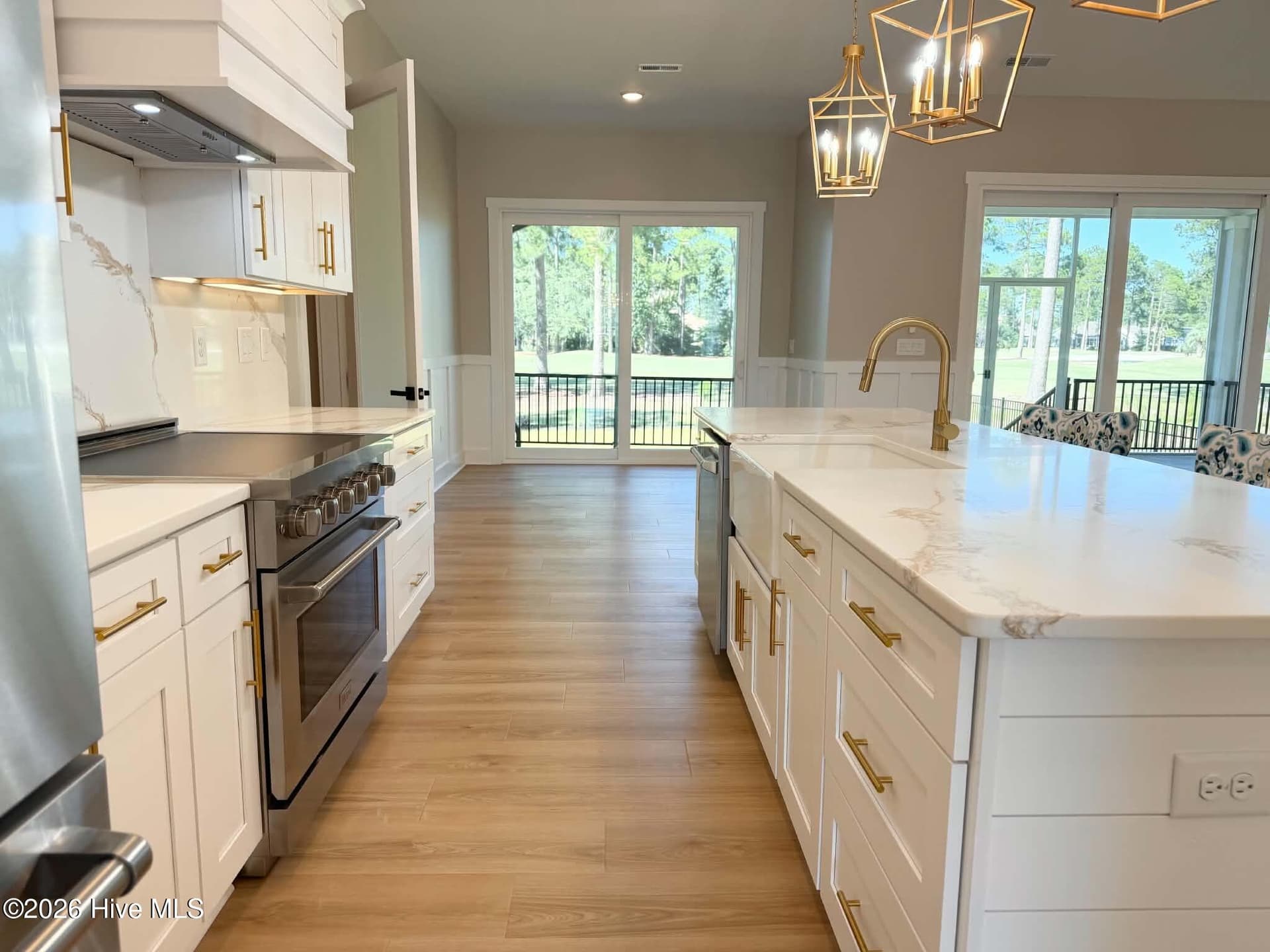 Kitchen area with view of breakfast area. Custom lighting, counter tops, backsplash, faucet and cabinet hardware. Upgraded induction range. - 550 Glenburnie Street NW, Calabash, NC 28467