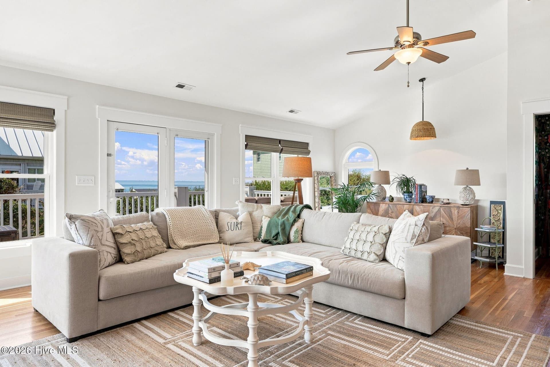 Light-filled living area featuring custom craftsman-style trim, large windows, and an inviting open-concept design. - 103 Georgia Street, Emerald Isle, NC 28594