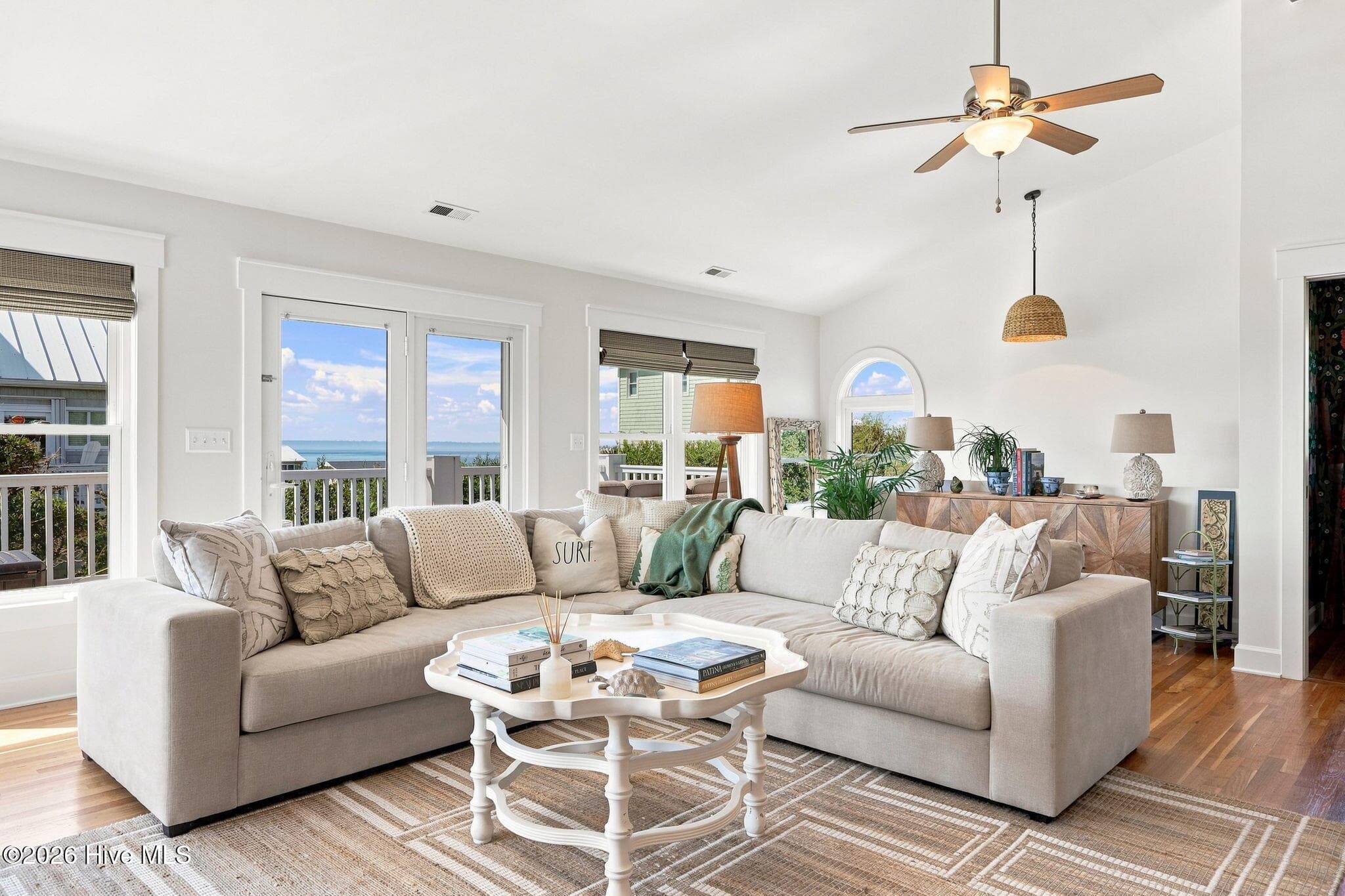 Light-filled living area featuring custom craftsman-style trim, large windows, and an inviting open-concept design. - 103 Georgia Street, Emerald Isle, NC 28594