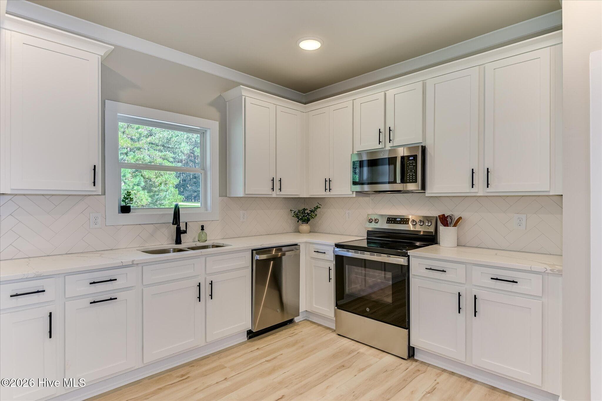 Well-equipped kitchen with quartz countertops, stainless steel appliances, and pantry - 1198 Sunset Cove, Tignall, GA 30668