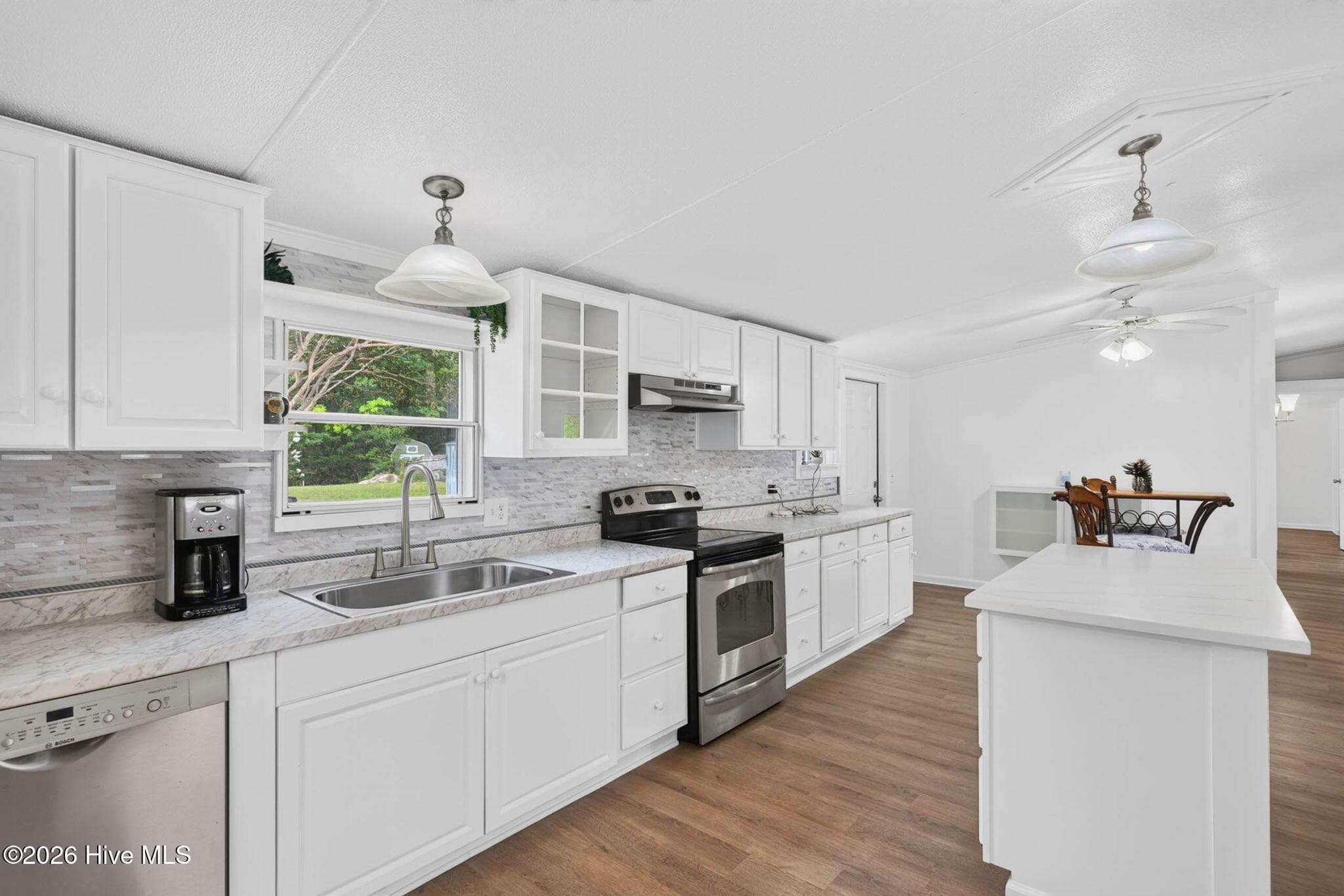 The renovated kitchen offers ample cabinet storage, expansive countertops, modern appliances, and plenty of workspace for everyday cooking. - 1199 Zack Street SE, Bolivia, NC 28422