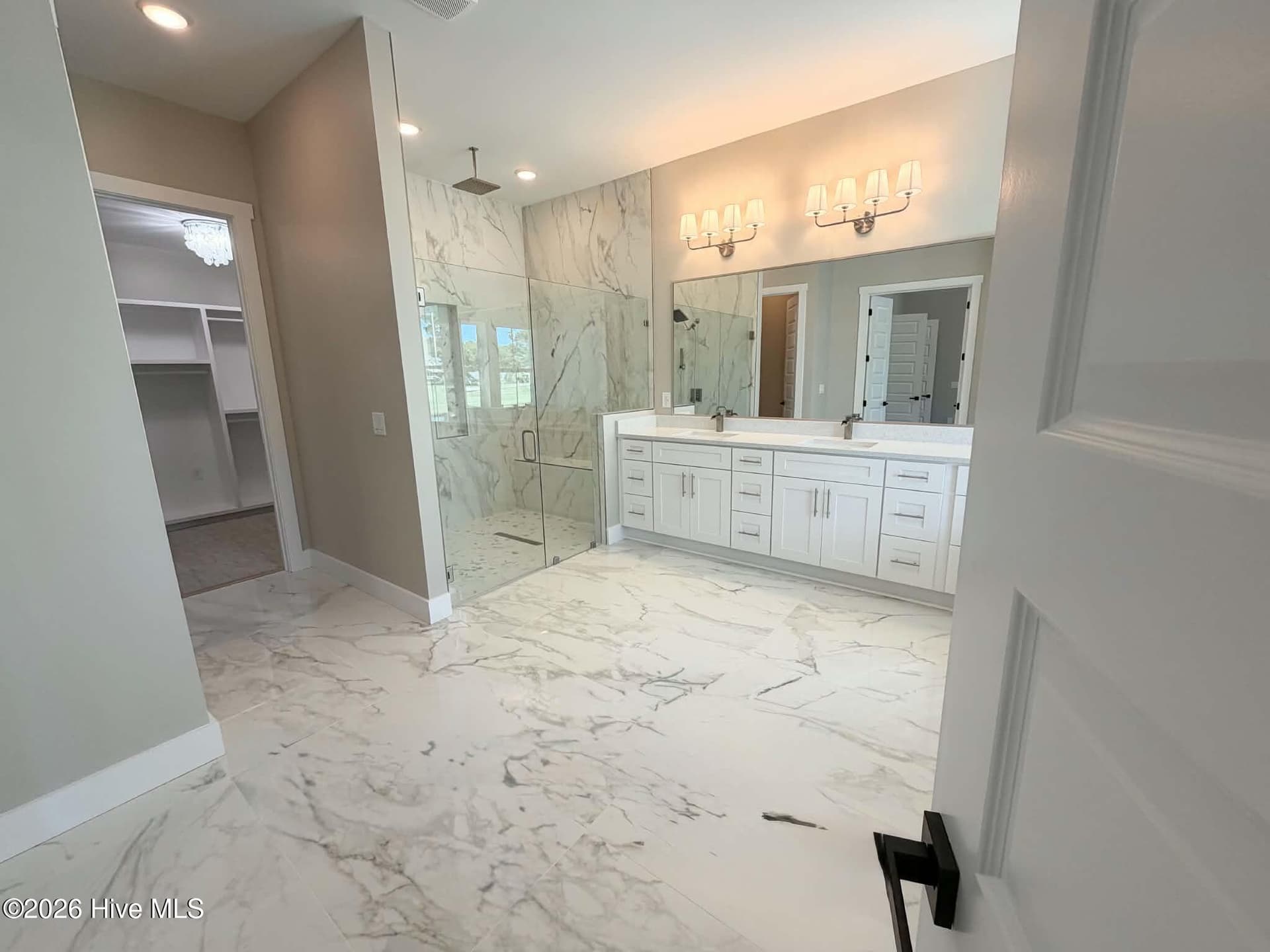 Primary bath including rain shower head, custom walk in closet, large soaking tub and custom mirrors and lighting. - 550 Glenburnie Street NW, Calabash, NC 28467