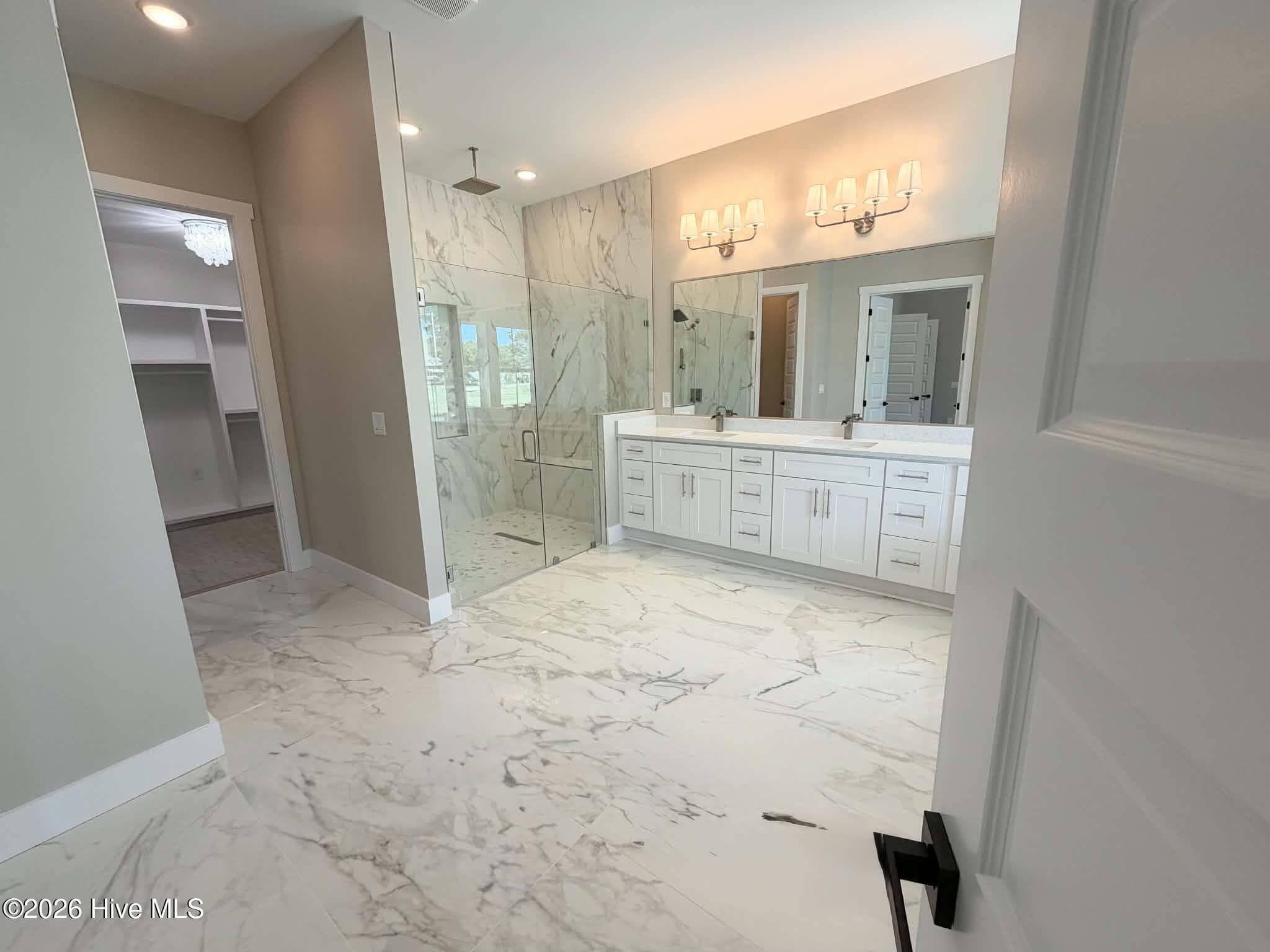 Primary bath including rain shower head, custom walk in closet, large soaking tub and custom mirrors and lighting. - 550 Glenburnie Street NW, Calabash, NC 28467