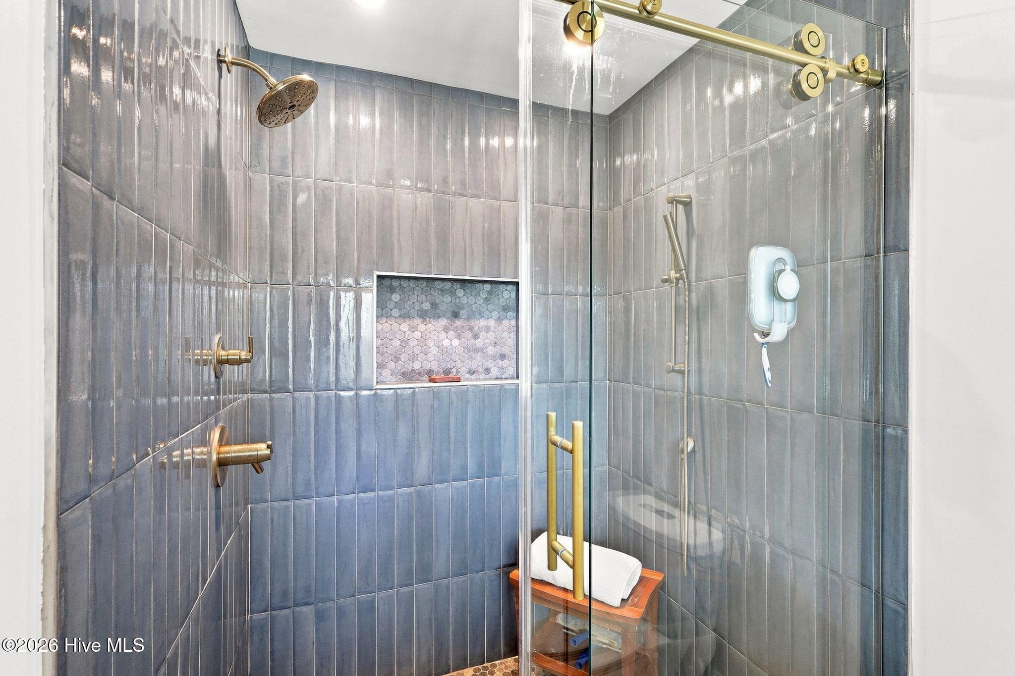 Spa-inspired primary bathroom featuring heated tile floors and a stunning custom-tiled walk-in shower. - 103 Georgia Street, Emerald Isle, NC 28594