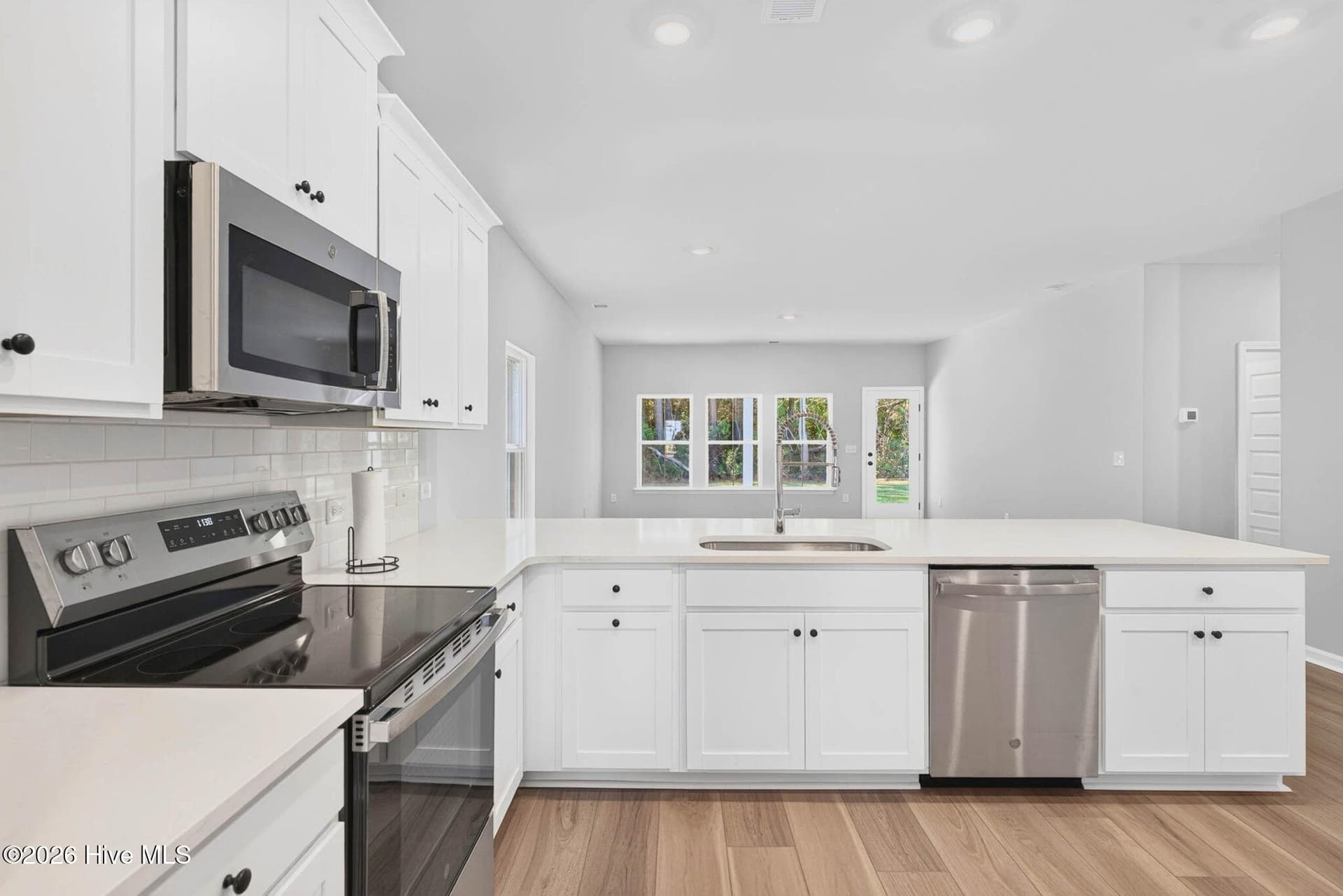Beautifully appointed kitchen featuring white cabinetry, stainless steel appliances, and quartz countertops. - 3447 Sandhill Crane Drive SW, Ocean Isle Beach, NC 28469