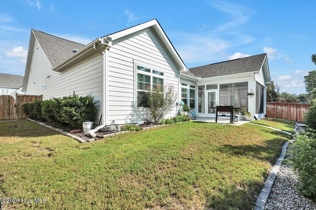 With its extended patio and enclosed 3-season room, this irrigated, beautifully landscaped sloping backyard is easy to maintain. - 142 Rice Marsh Way, Wilmington, NC 28412