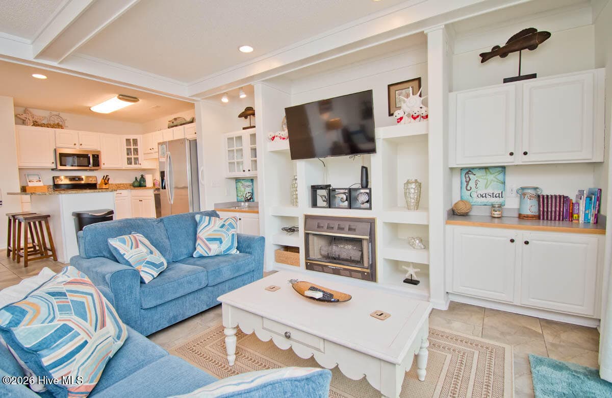 The unit features tile flooring and a cozy gas fireplace in the living room, creating an inviting space to unwind after a day at the beach. - 2909 Pointe West Drive 3b1, Emerald Isle, NC 28594