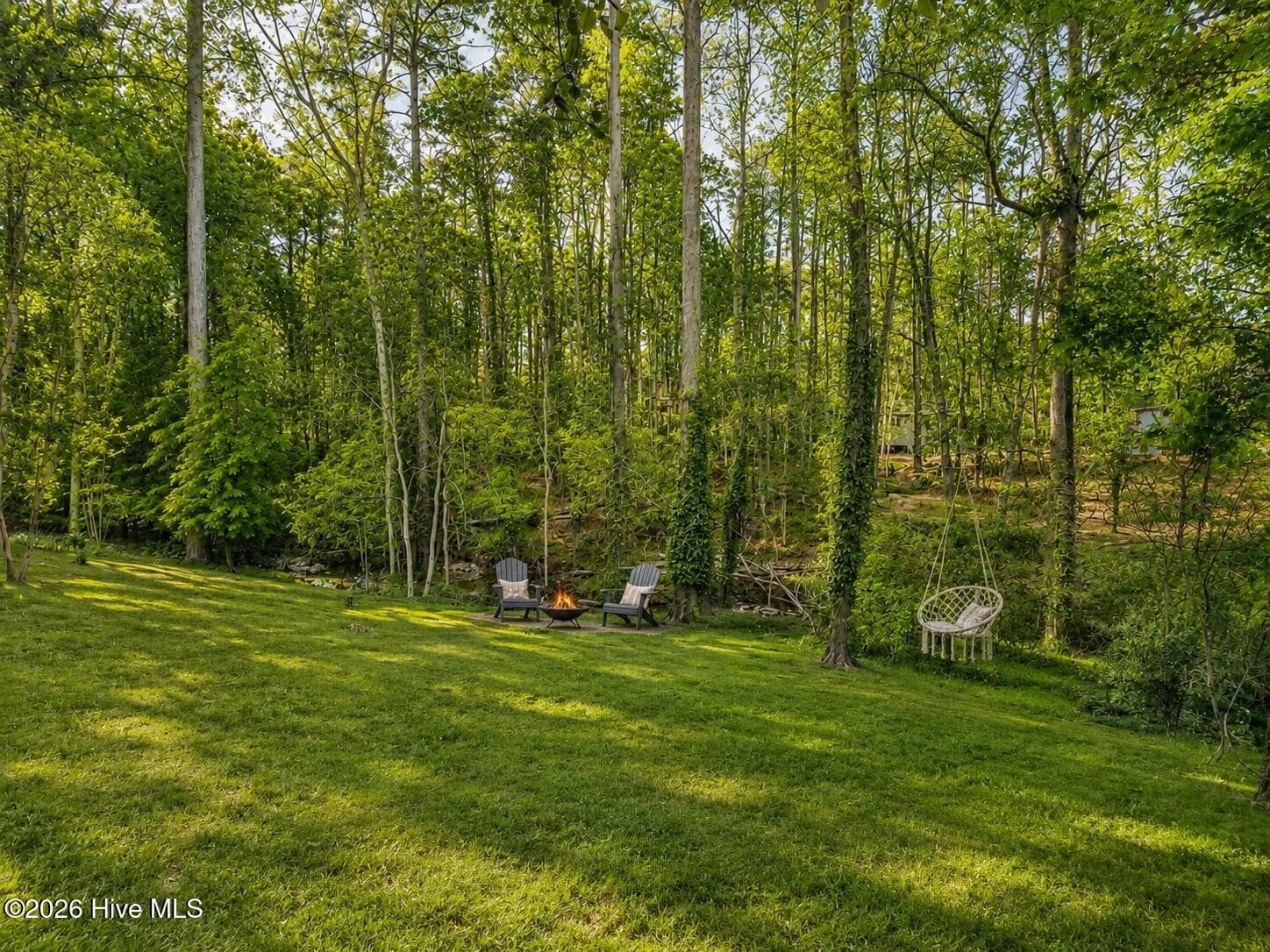 A private, tree-filled backyard retreat with space to gather, relax, and enjoy peaceful evenings by the fire. - 16 Rapids Court, North Augusta, SC 29841