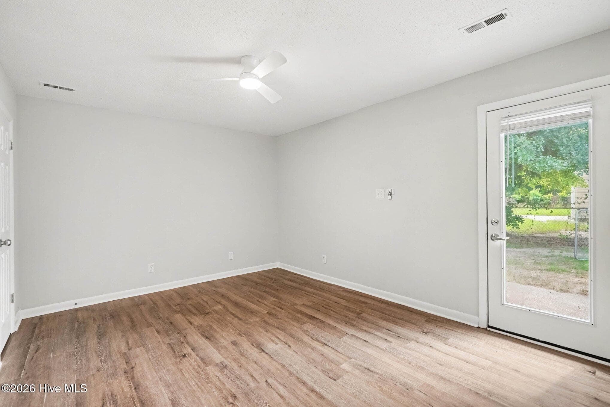 Spacious primary suite featuring modern ceiling fan, access to a private patio, and abundant space offering versatile furniture arrangement options. - 108 Deerfield Drive, Spring Lake, NC 28390