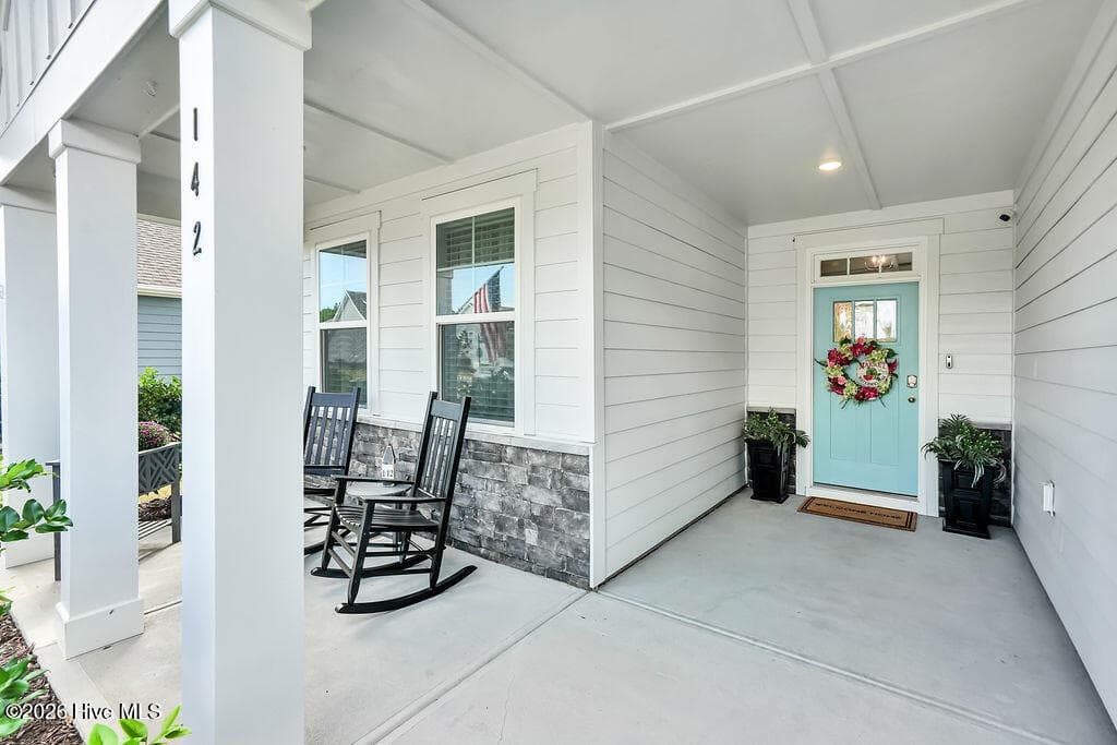 The charming front porch features durable fiber cement and stone siding, and recessed lighting. - 142 Rice Marsh Way, Wilmington, NC 28412
