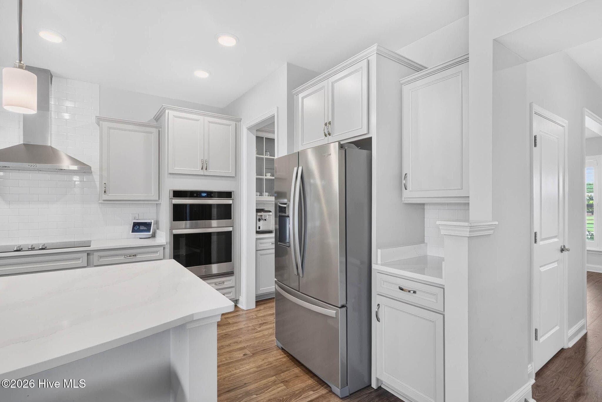The well-appointed kitchen includes stainless steel appliances, an electric cooktop, built-in oven, microwave, and refrigerator. - 139 Eagle Claw Drive, Calabash, NC 28467