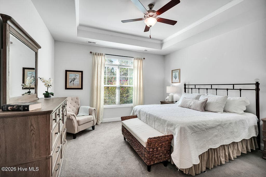 Just beyond a pair of double doors, the owner's suite is a true private retreat with a spa-like bathroom complete with upgraded L-shaped tiled shower, transom window upgrade, solar tube style sun tunnel, double sink vanity and two spacious walk-in closets. One of these passes through to the laundry room with its built-in folding station. - 142 Rice Marsh Way, Wilmington, NC 28412