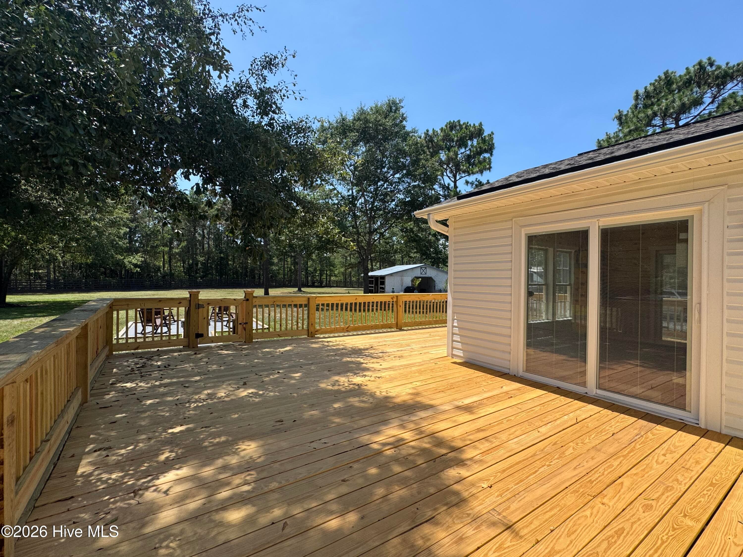 Sliding glass door open up to a bright and airy sunroom - 1265 Gilbert Road SE, Bolivia, NC 28422