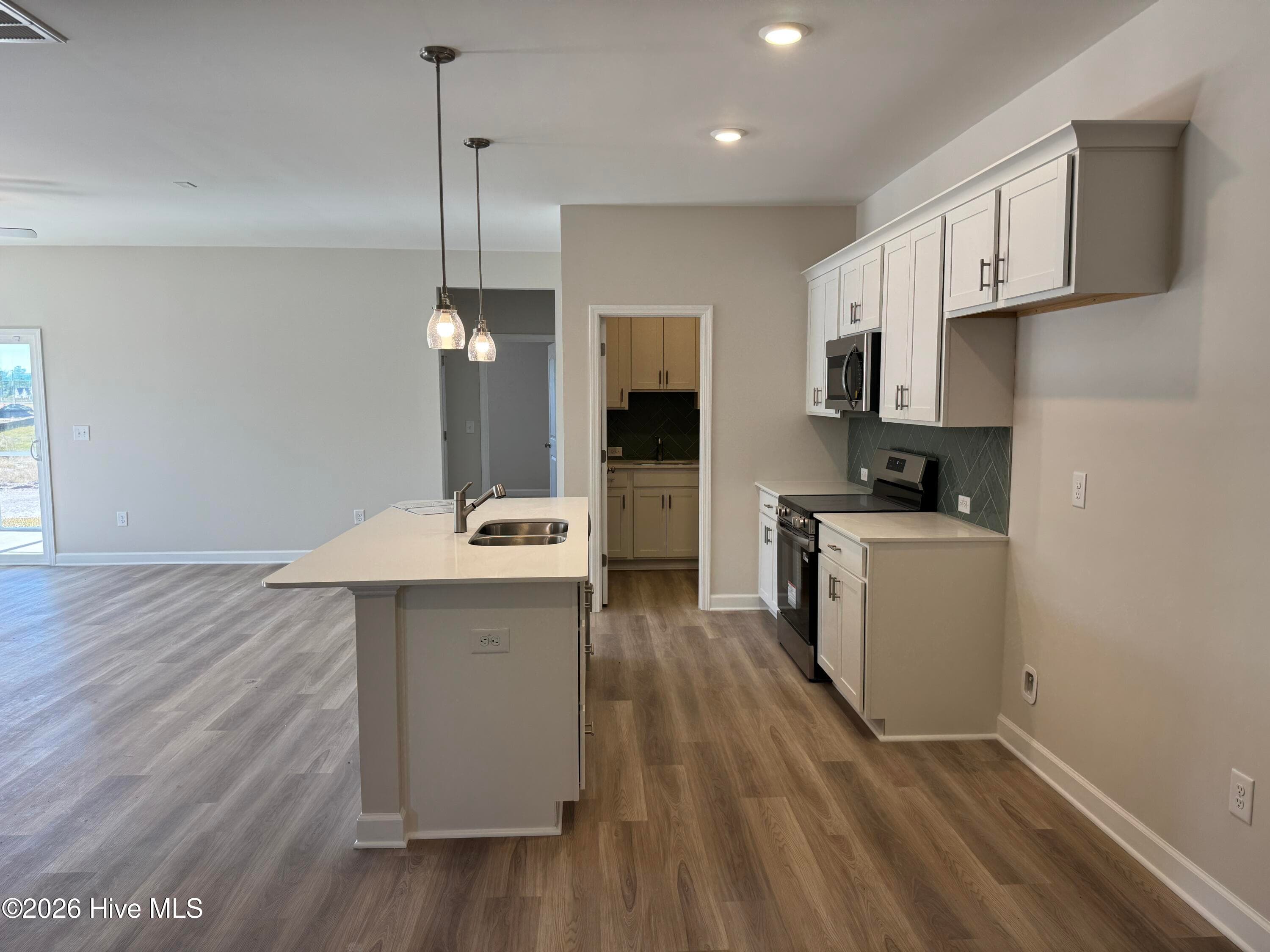 Elegant Kitchen includes Deluxe Pantry, Quartz Countertops, Stainless Appliances, Tile Backsplash, and Beautiful Lighting fixtures. - 4145 Workman Loop 66, Leland, NC 28451