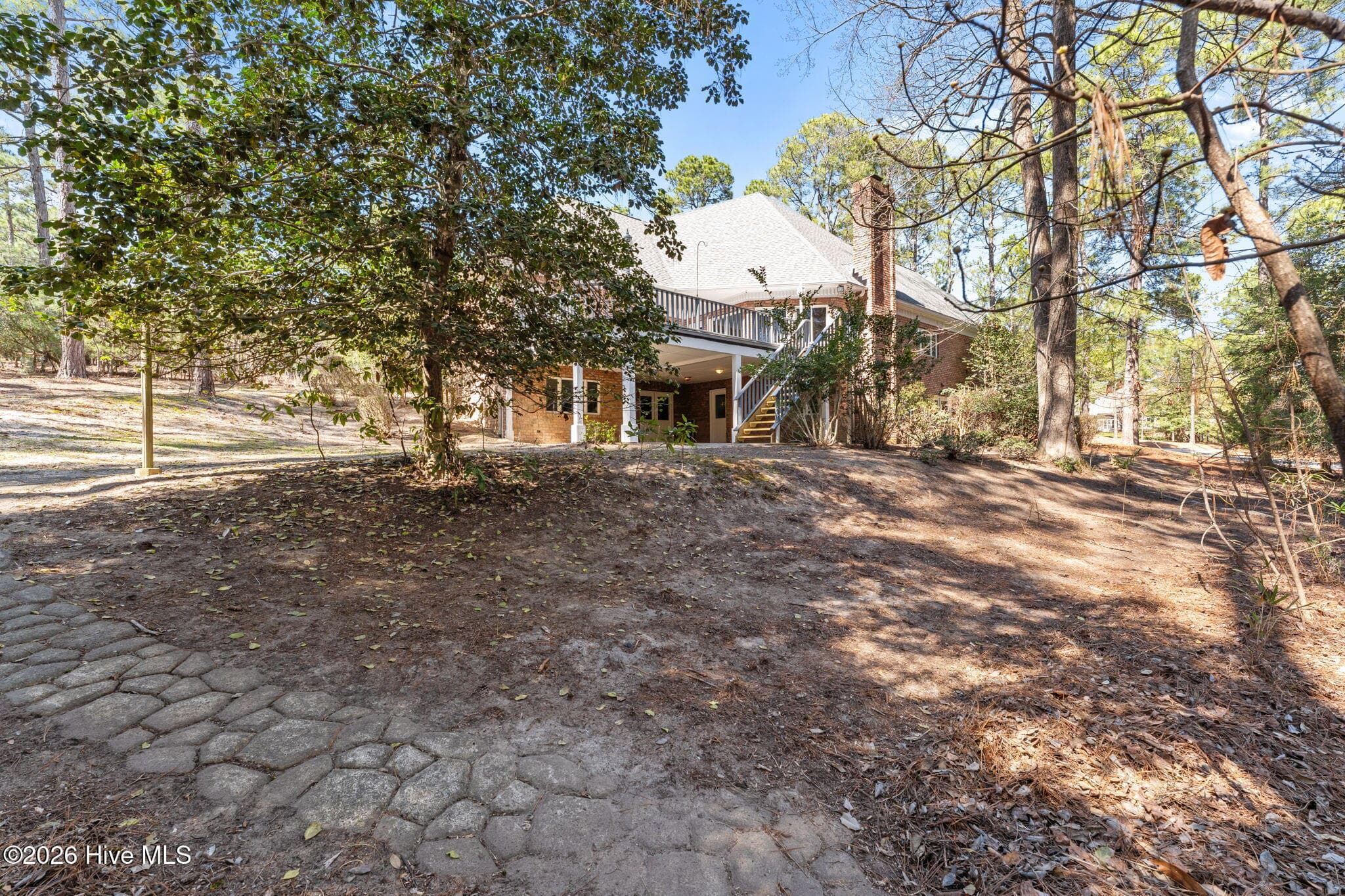 Backyard with a pathway down to the creek which has a rest area to enjoy. - 22 Lochmere Drive, Pinehurst, NC 28374
