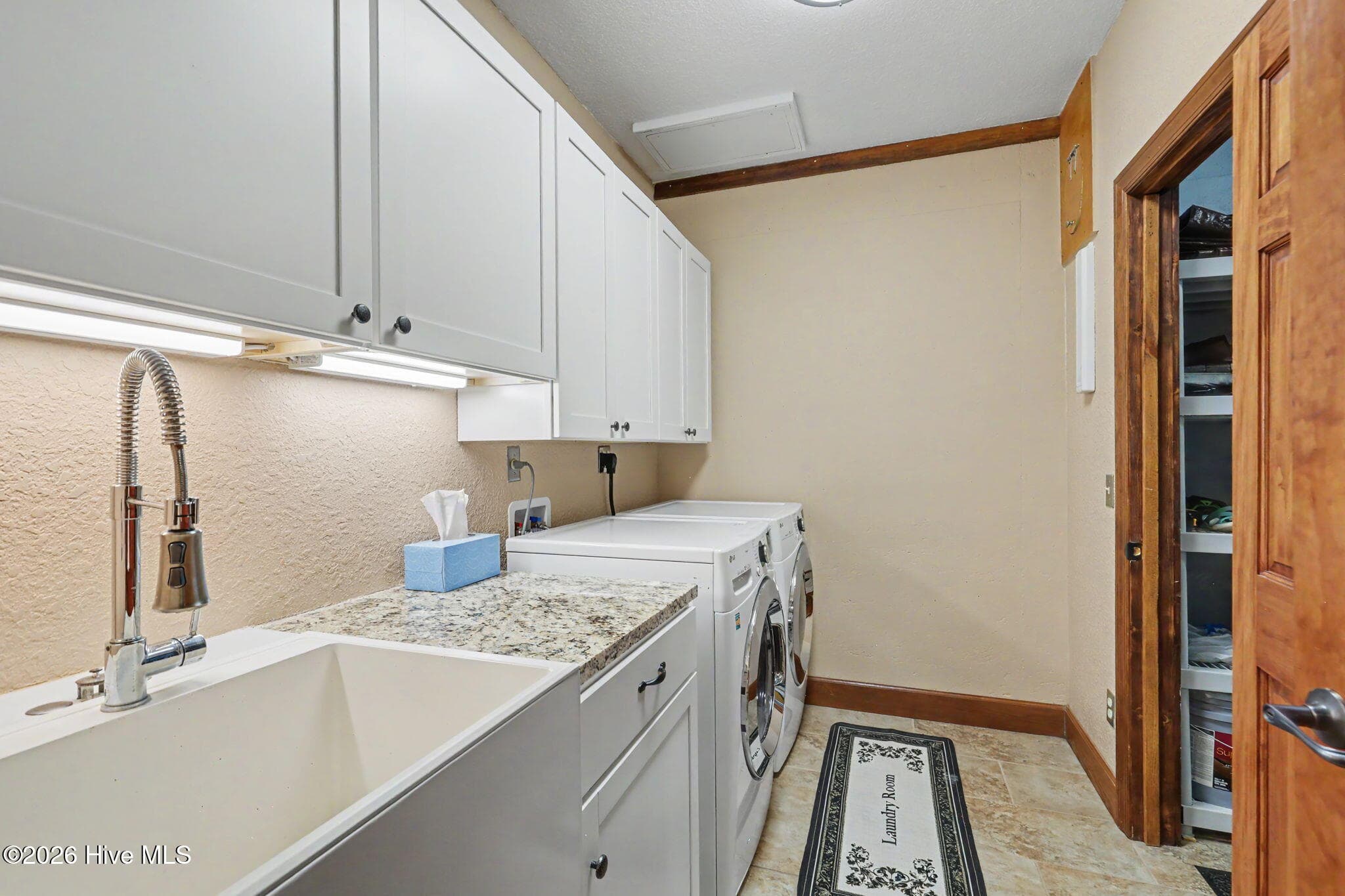 Dedicated laundry room with extensive cabinetry and utility sink. - 210 Majestic Drive, Hayesville, NC 28904