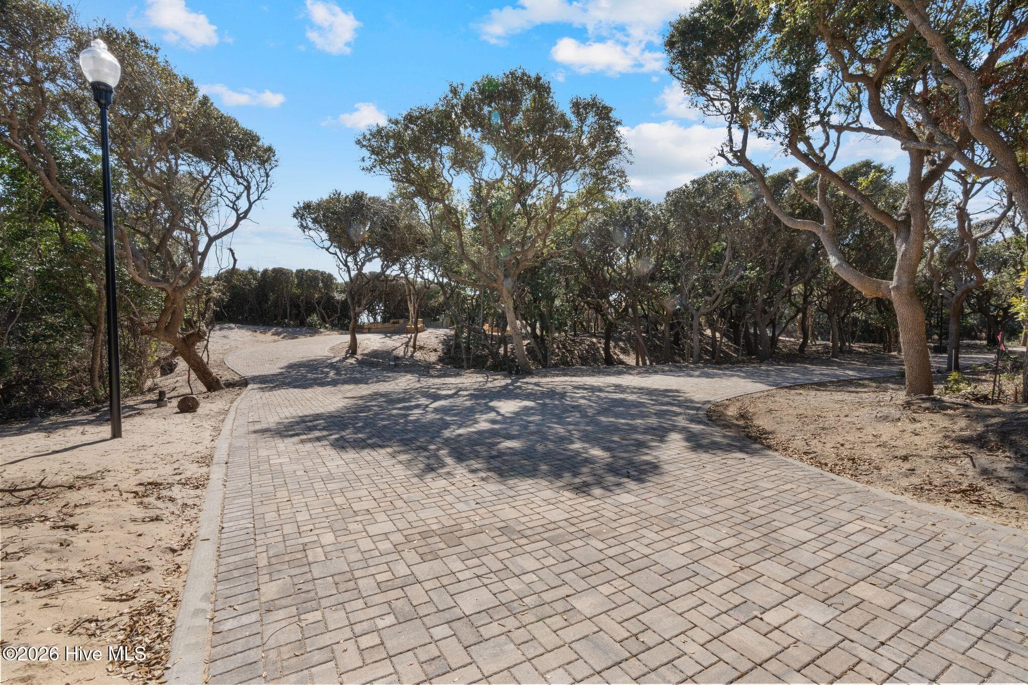 A charming brick-paver loop road winds through Roosevelt Reserve, connecting the future custom homesites and setting the stage for an intimate collection of distinctive coastal residences within this rare beachfront offering. - 103 Lot 2 2 Roosevelt Reserve Park Lane, Pine Knoll Shores, NC 28512
