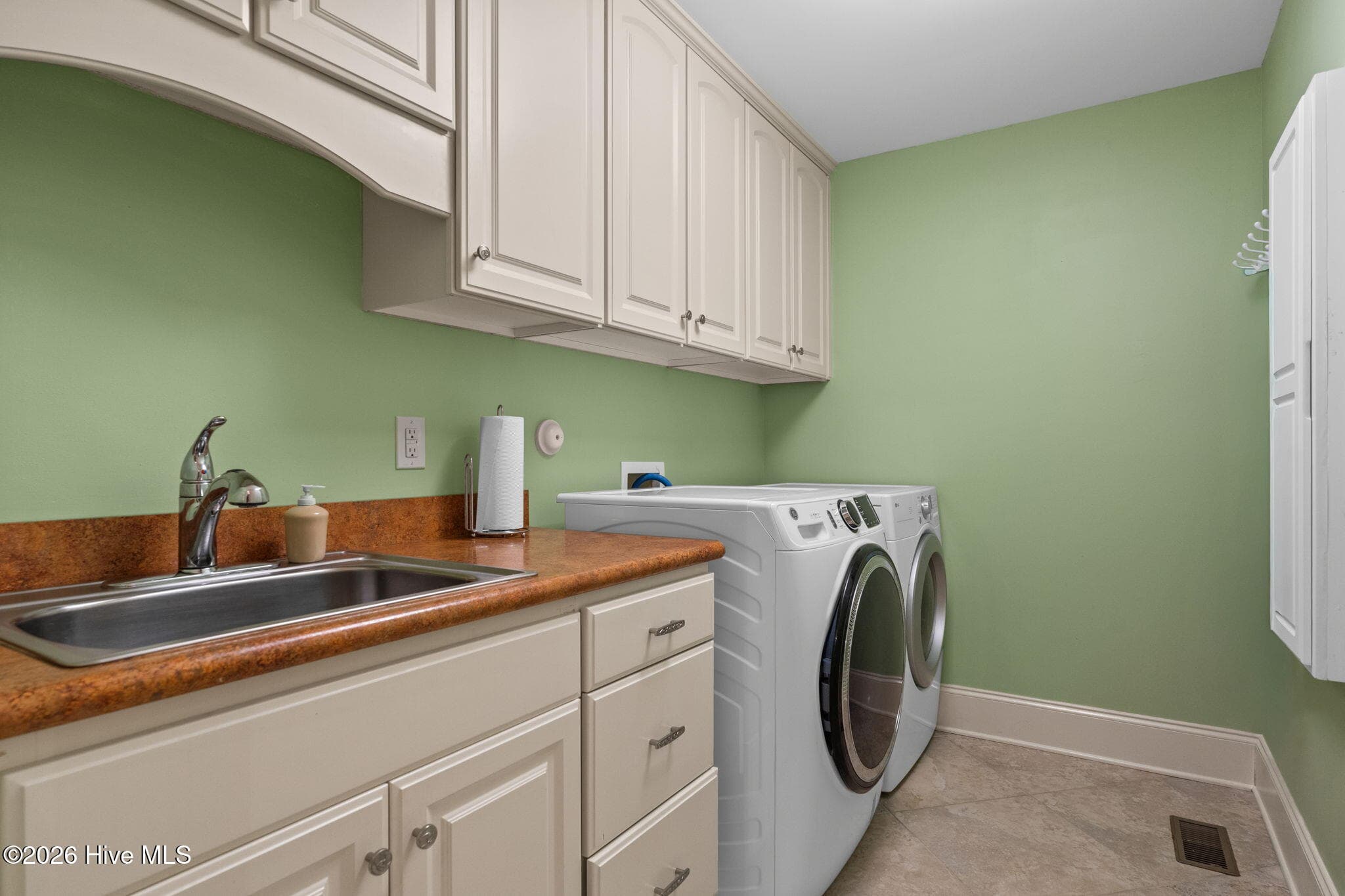 Laundry room with sink, ironing board and cabinets - 3858 Ridge Crest Drive, Southport, NC 28461