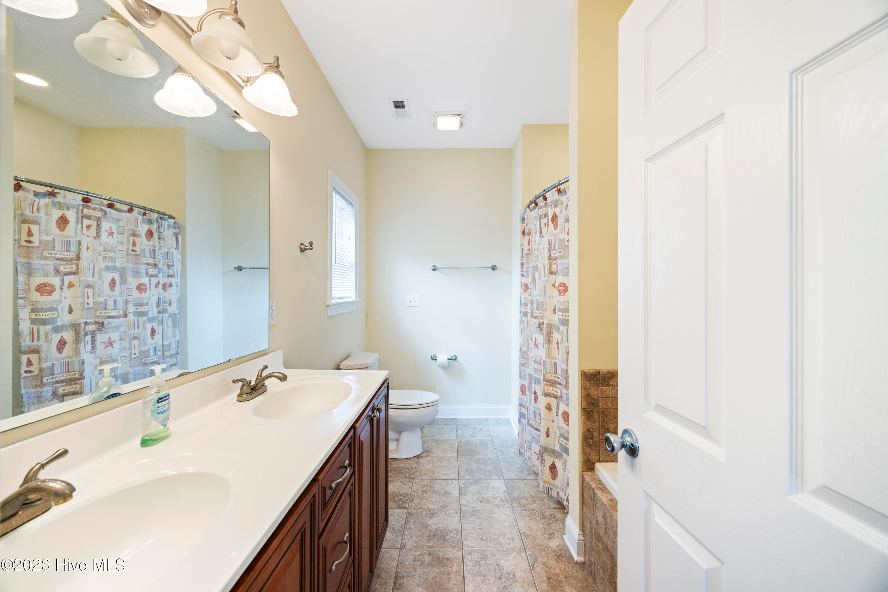PRIMARY BEDROOM's En Suite Bathroom features Double Vanity - 225 NE 39th Street, Oak Island, NC 28465