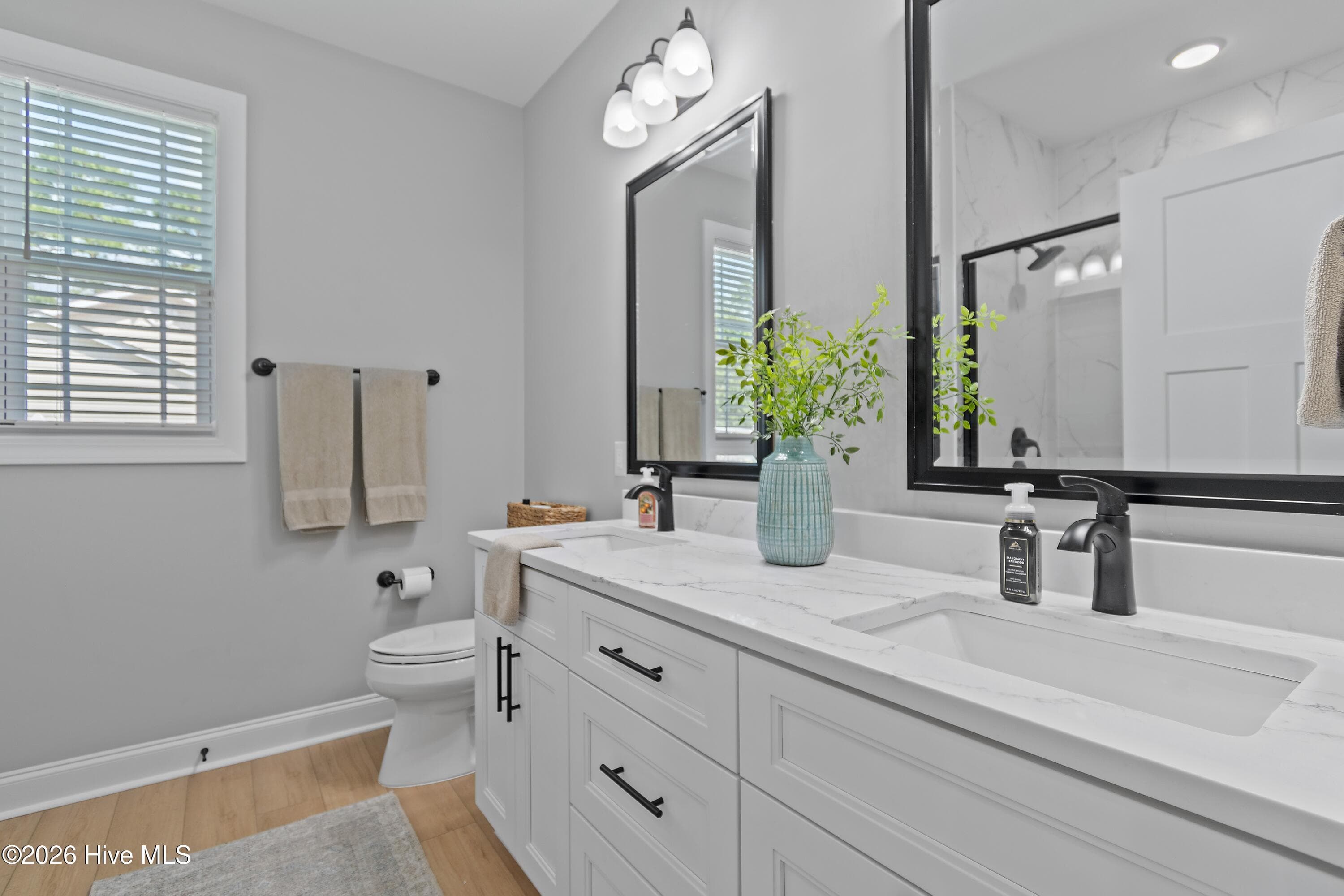Primary bathroom with dual vanities and quartz countertops. - 299 Boundaryline Drive NW, Calabash, NC 28467