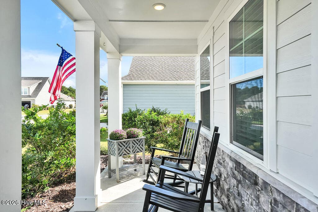 The charming front porch features durable fiber cement and stone siding, and recessed lighting. - 142 Rice Marsh Way, Wilmington, NC 28412
