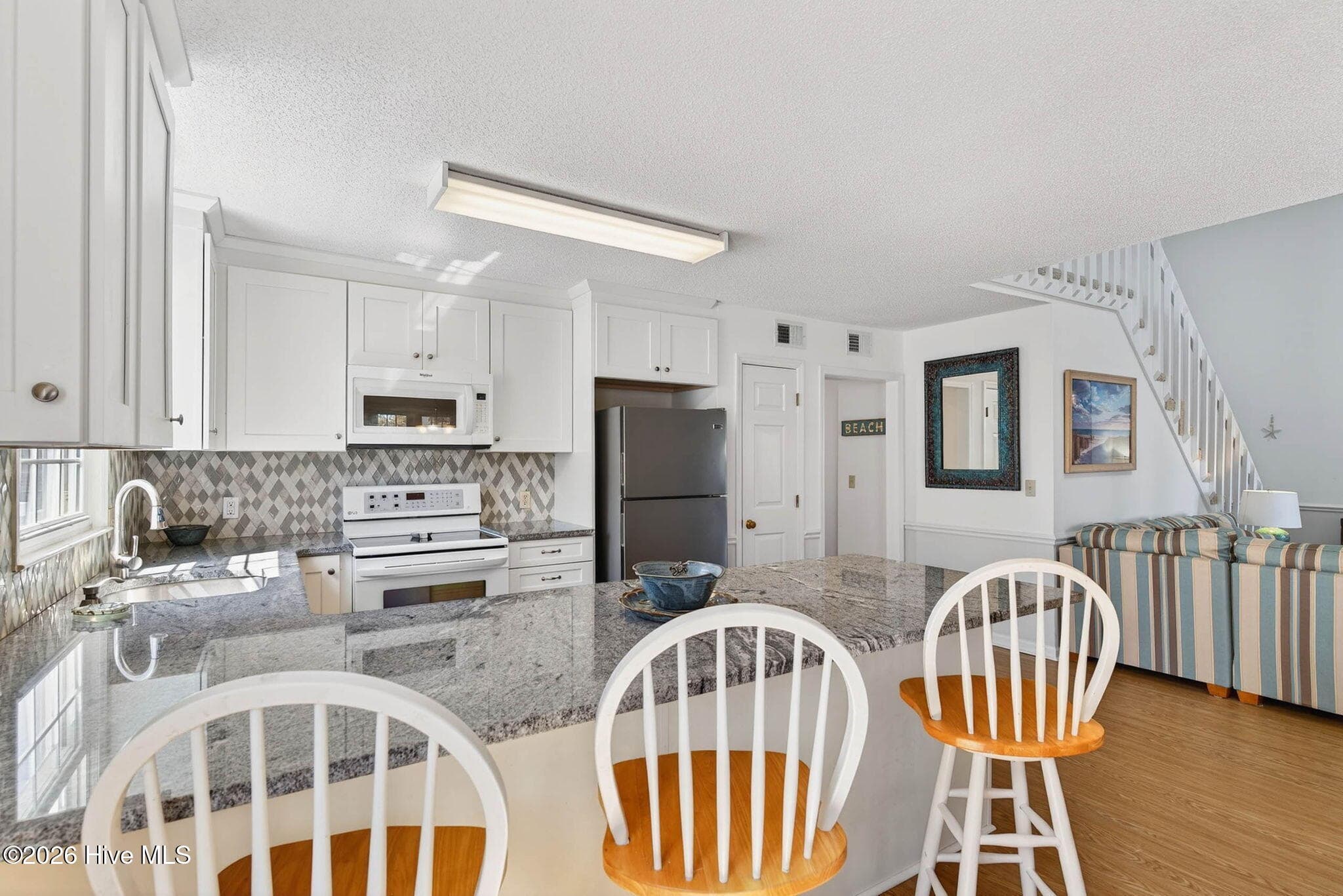 Coastal dining area with open flow to kitchen and living room. - 1206 N Shore Drive W, Sunset Beach, NC 28468