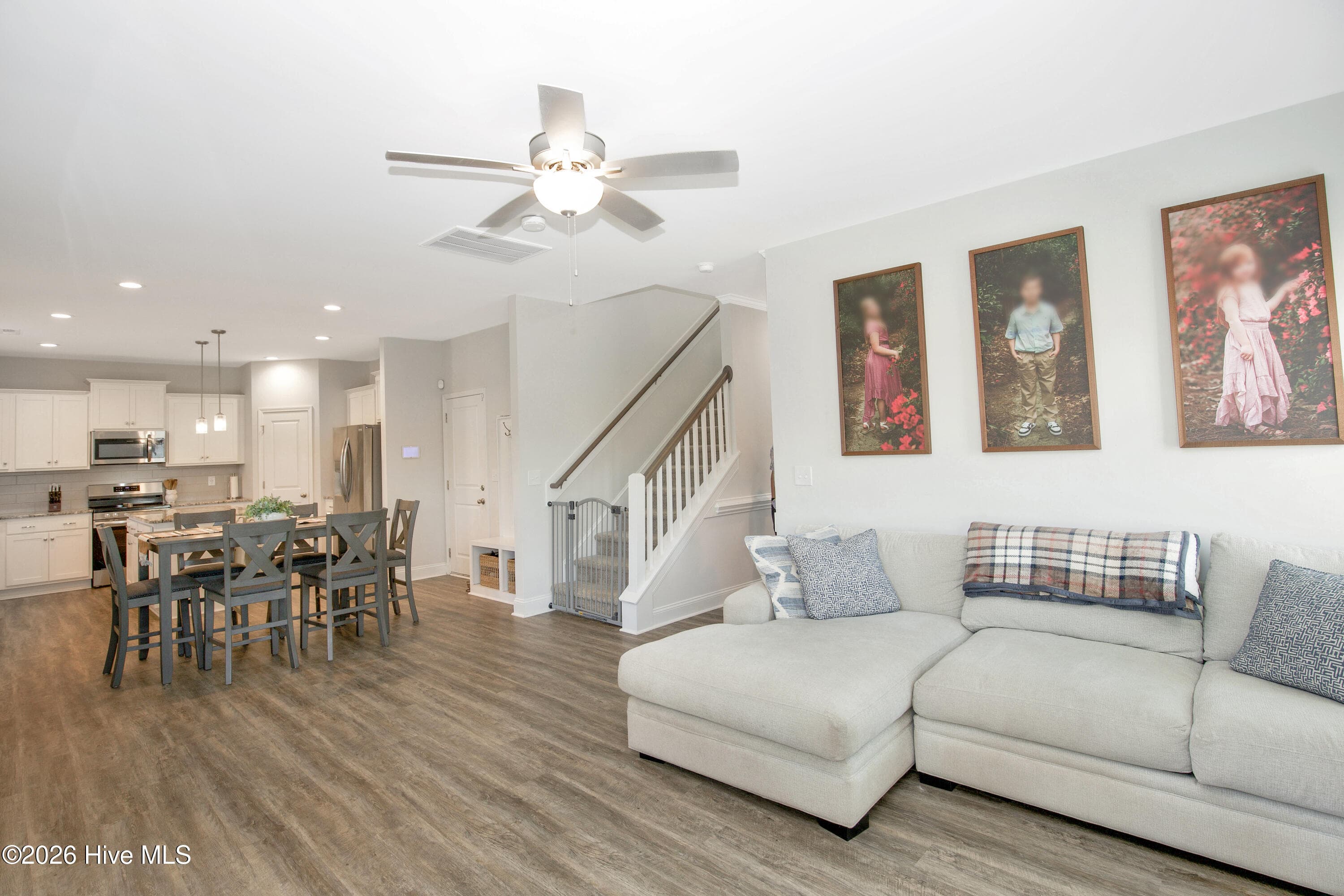 This wide view shows the full sweep of the main level, from the Great Room seating area to the staircase and the kitchen at the far end. Wood-look flooring and consistent light gray walls carry from room to room. Seeing the spaces together gives a clear sense of how the 915 square feet of heated space on the first floor is put to use. - 221 Vega Lane, Linden, NC 28356