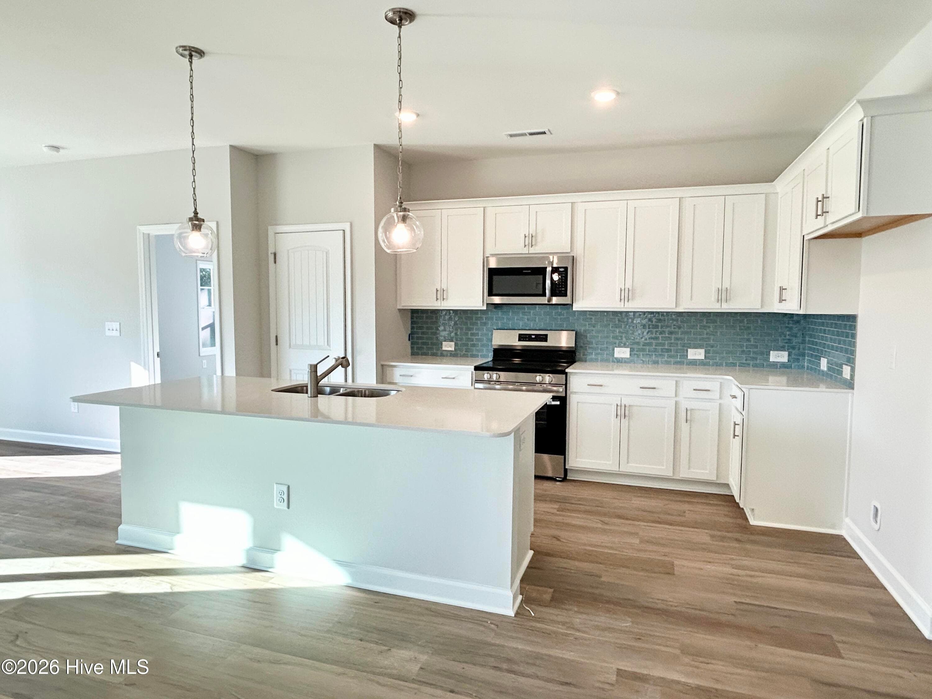 Elegant Kitchen includes Quartz Countertops, Stainless Appliances, Tile Backsplash, and Beautiful Lighting fixtures. - 4149 Workman Loop 67, Leland, NC 28451