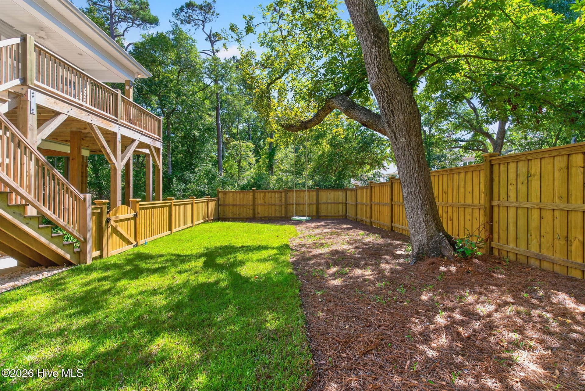 Serene, tree covered back yard with steps to back porch - 101 SE 14th Street, Oak Island, NC 28465