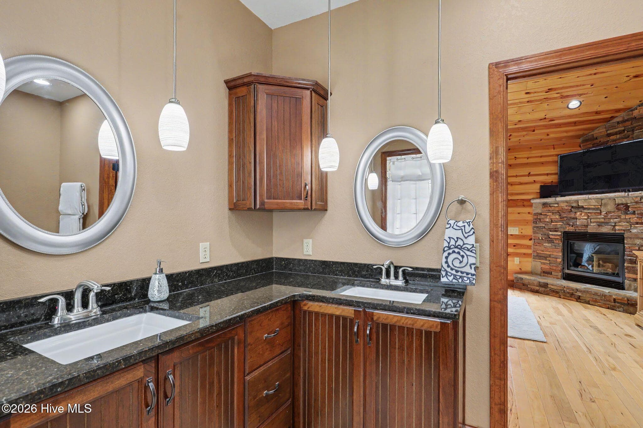 Dual vanity area offers abundant counter space, while custom cabinetry echoes the kitchen finishes for a cohesive design throughout the home. - 210 Majestic Drive, Hayesville, NC 28904