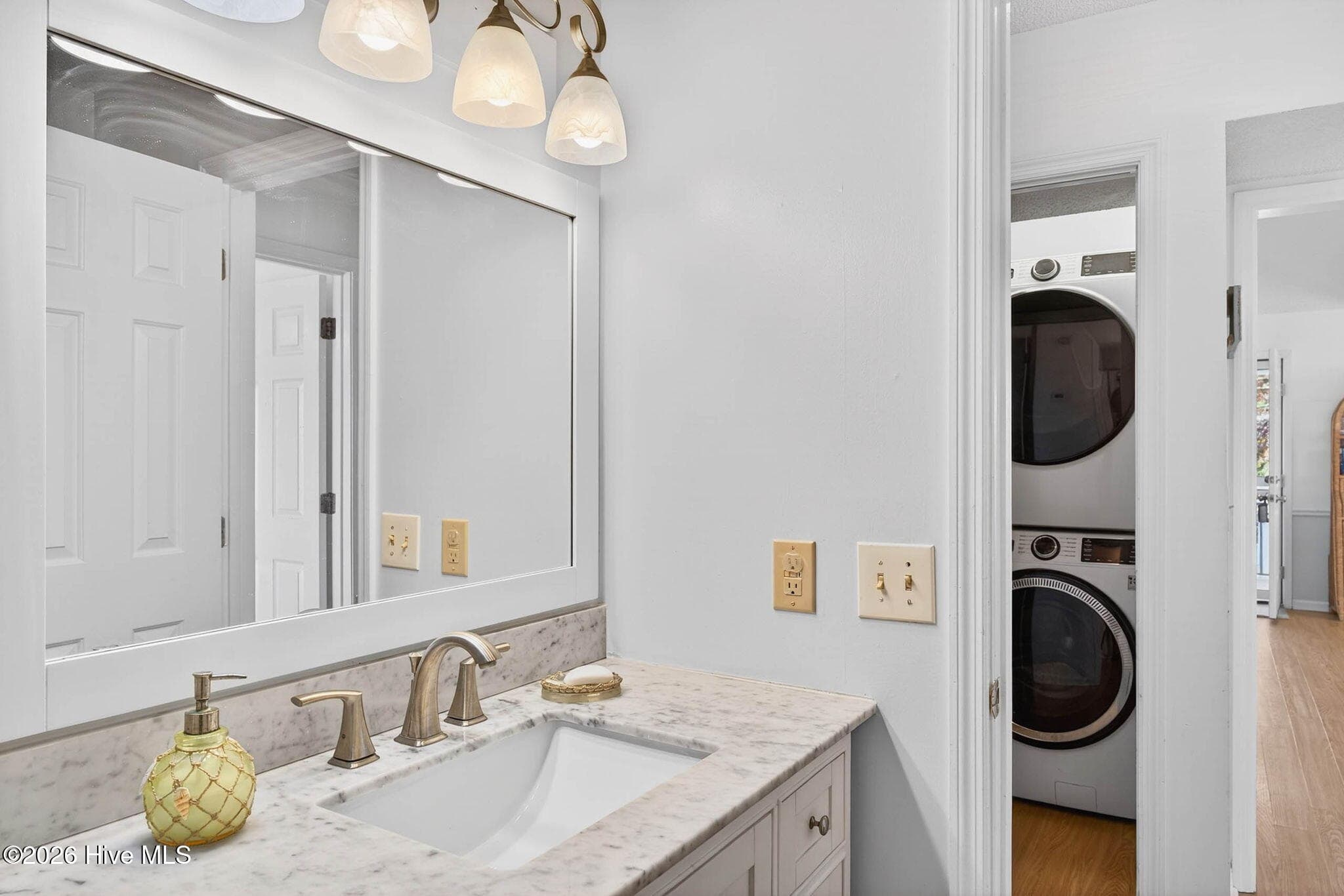Remodeled bathroom featuring extended vanity, bright lighting, and clean coastal design. - 1206 N Shore Drive W, Sunset Beach, NC 28468