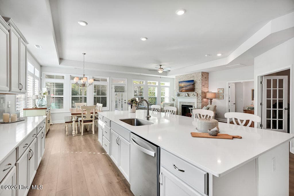 Chef-style kitchen island is the heart of this home and a natural gathering place. The kitchen also features upgraded premium staggered, color glazed cabinetry with dovetails, a single basin stainless sink, fully tiled backsplash throughout, upgraded stainless refrigerator and oven/range, upgraded granite countertops, brushed nickel lighting package, and custom plantation blinds. - 142 Rice Marsh Way, Wilmington, NC 28412