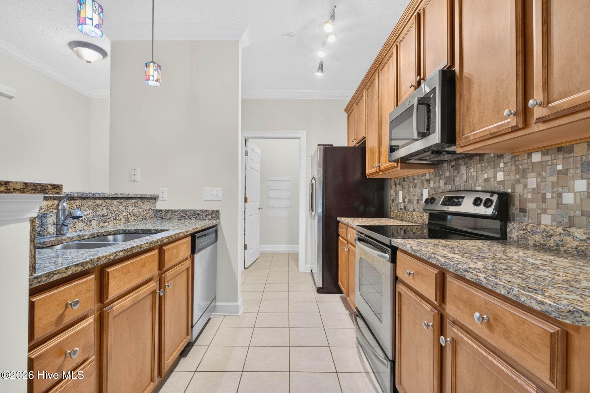 View of kitchen with laundry room at the end - 7825 High Market Street #303, Sunset Beach, NC 28468