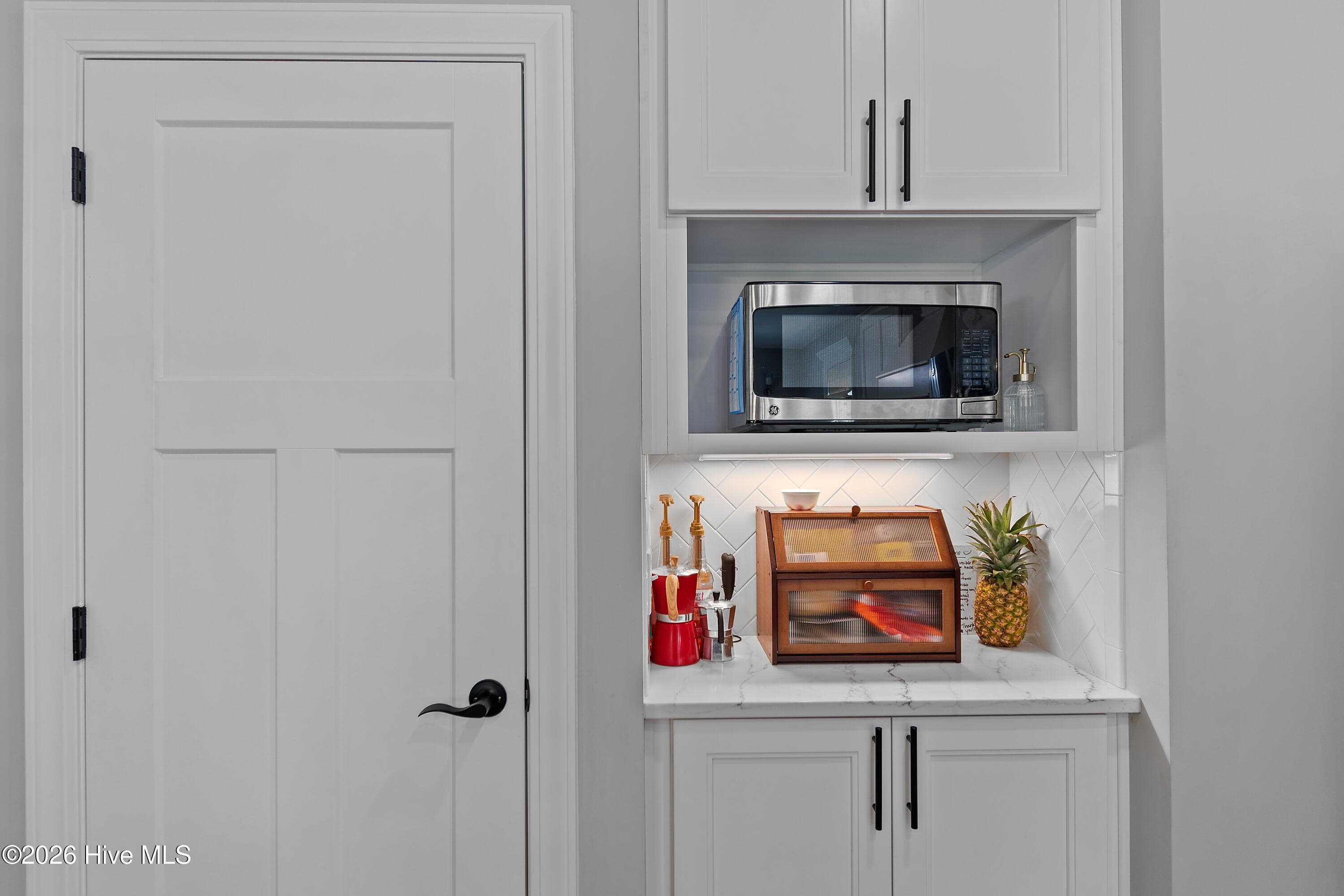 This area near the pantry offers additional cabinetry and counter space, providing extra room for storage, meal prep, serving, or creating the perfect coffee bar or appliance station. - 299 Boundaryline Drive NW, Calabash, NC 28467