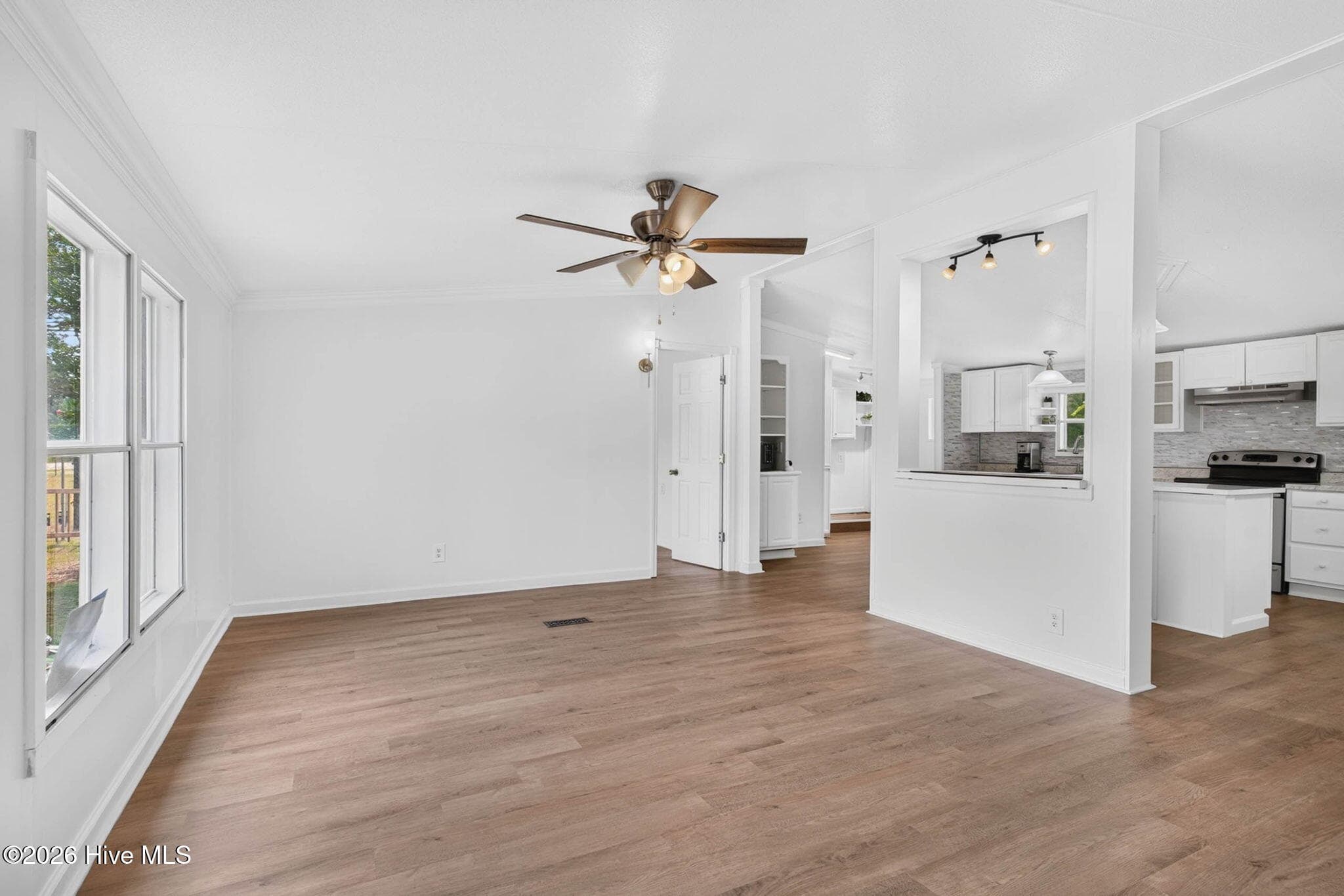Bright and spacious living room featuring luxury vinyl plank flooring, abundant natural light, and an open layout designed for comfortable everyday living. - 1199 Zack Street SE, Bolivia, NC 28422